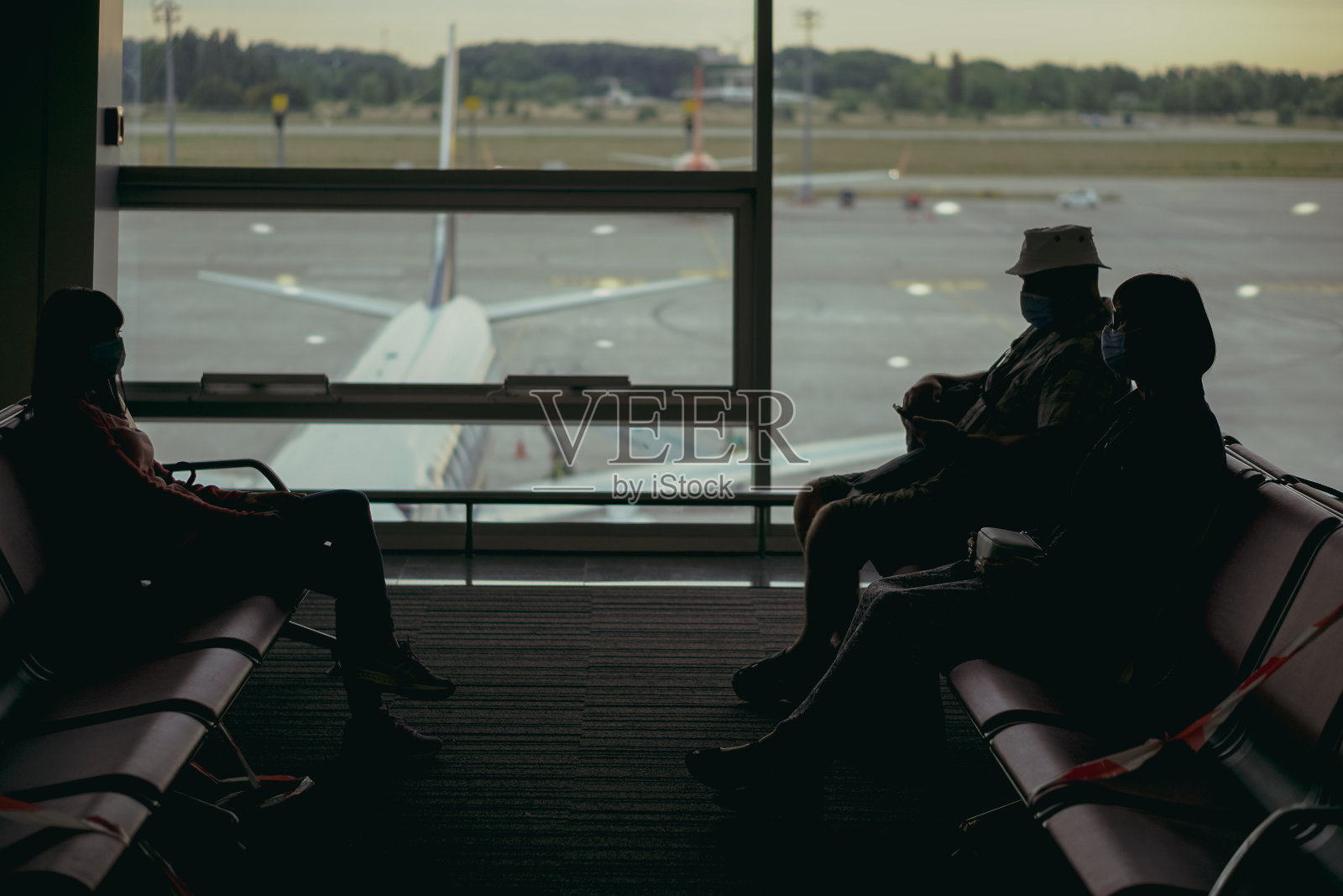 病毒。戴着医用口罩的人们在机场等待飞机航班照片摄影图片