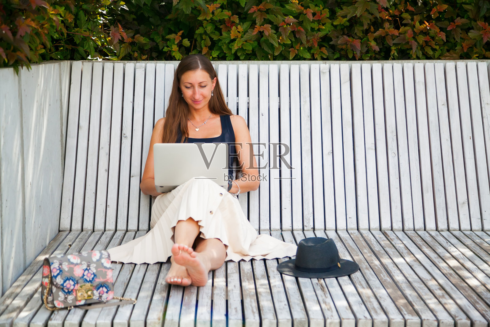 轻松的女人在公园里用笔记本电脑照片摄影图片