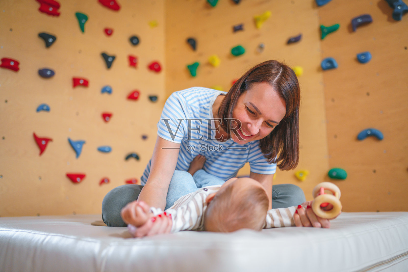 快乐的白人母亲在家里的游戏室和婴儿男孩玩照片摄影图片