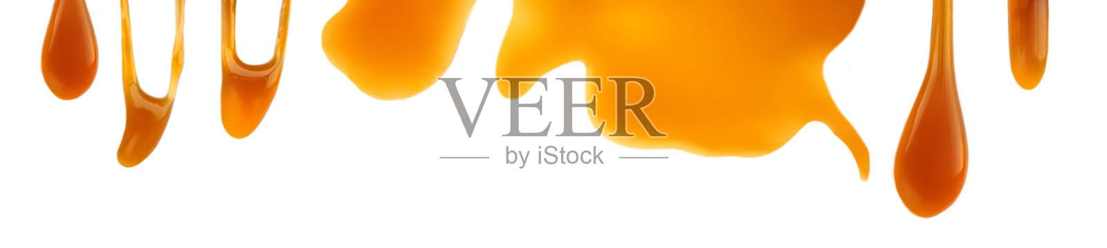 甜焦糖酱孤立在一个白色背景近距离。墙纸。焦糖全景照片摄影图片