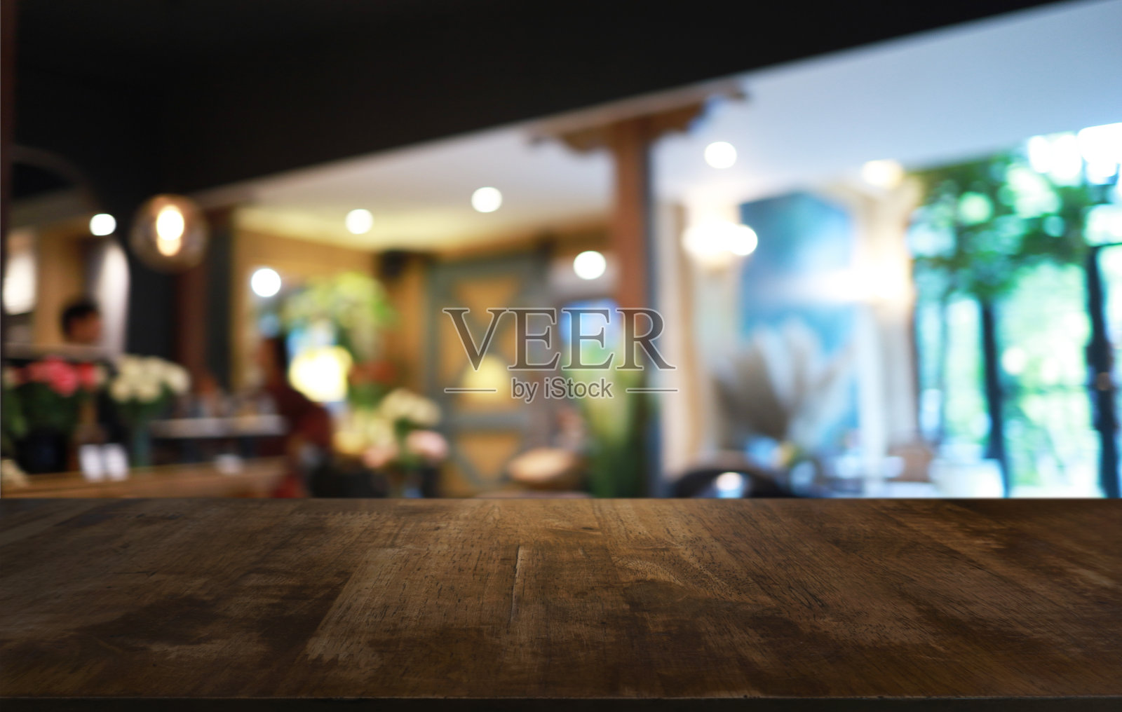 木质桌面在模糊的背景房间内部与空的复制空间。照片摄影图片