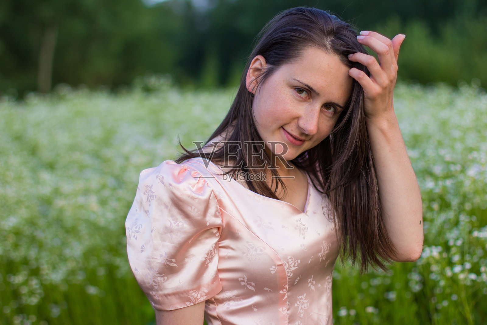 穿着粉红色裙子站在田野里的女孩照片摄影图片