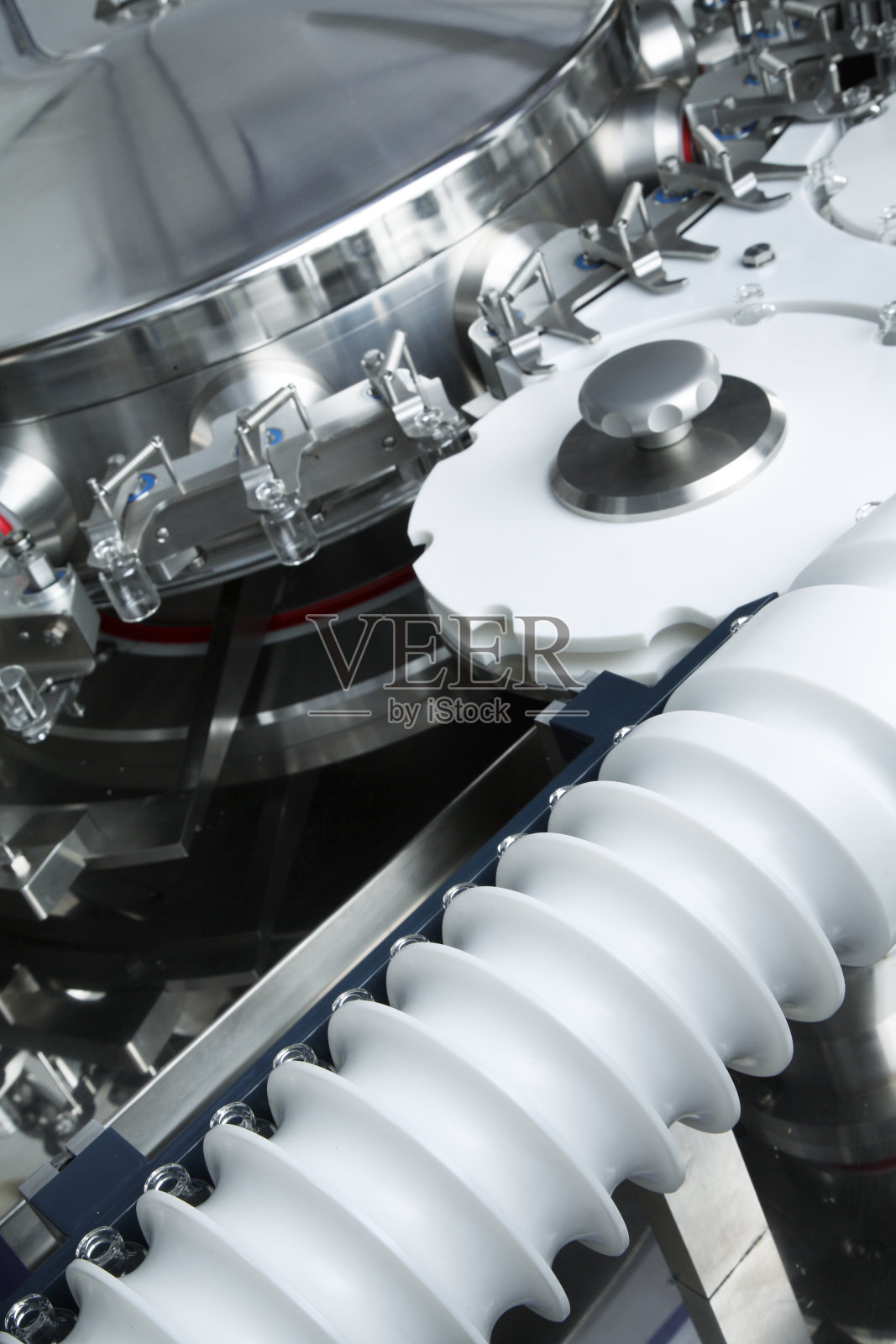 在自动液体分配器的托盘中生产的玻璃瓶,用于灌装抗细菌和病毒、抗生素和疫苗的药物照片摄影图片