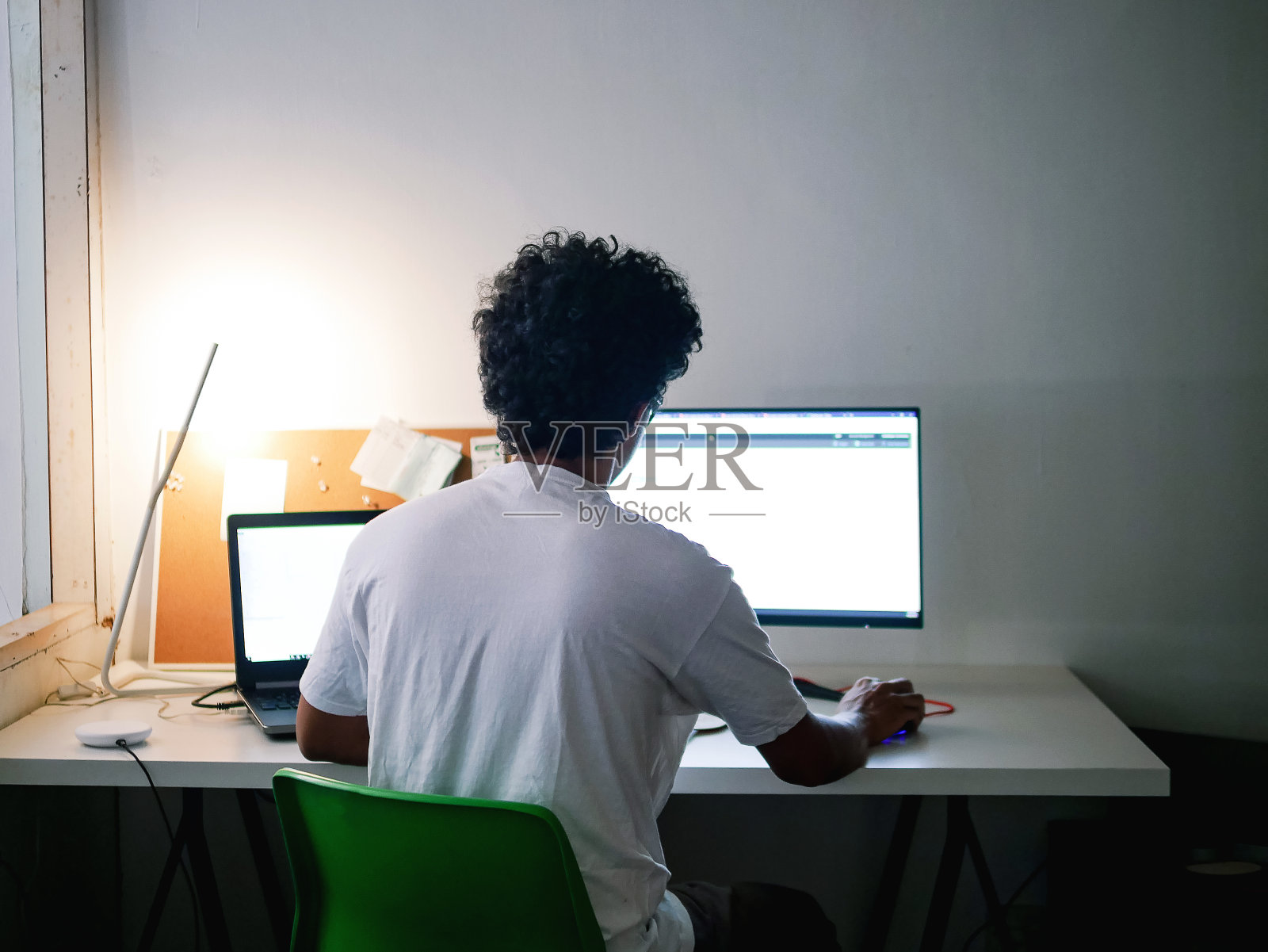 单身亚洲男人在家工作,用笔记本电脑和显示器照片摄影图片