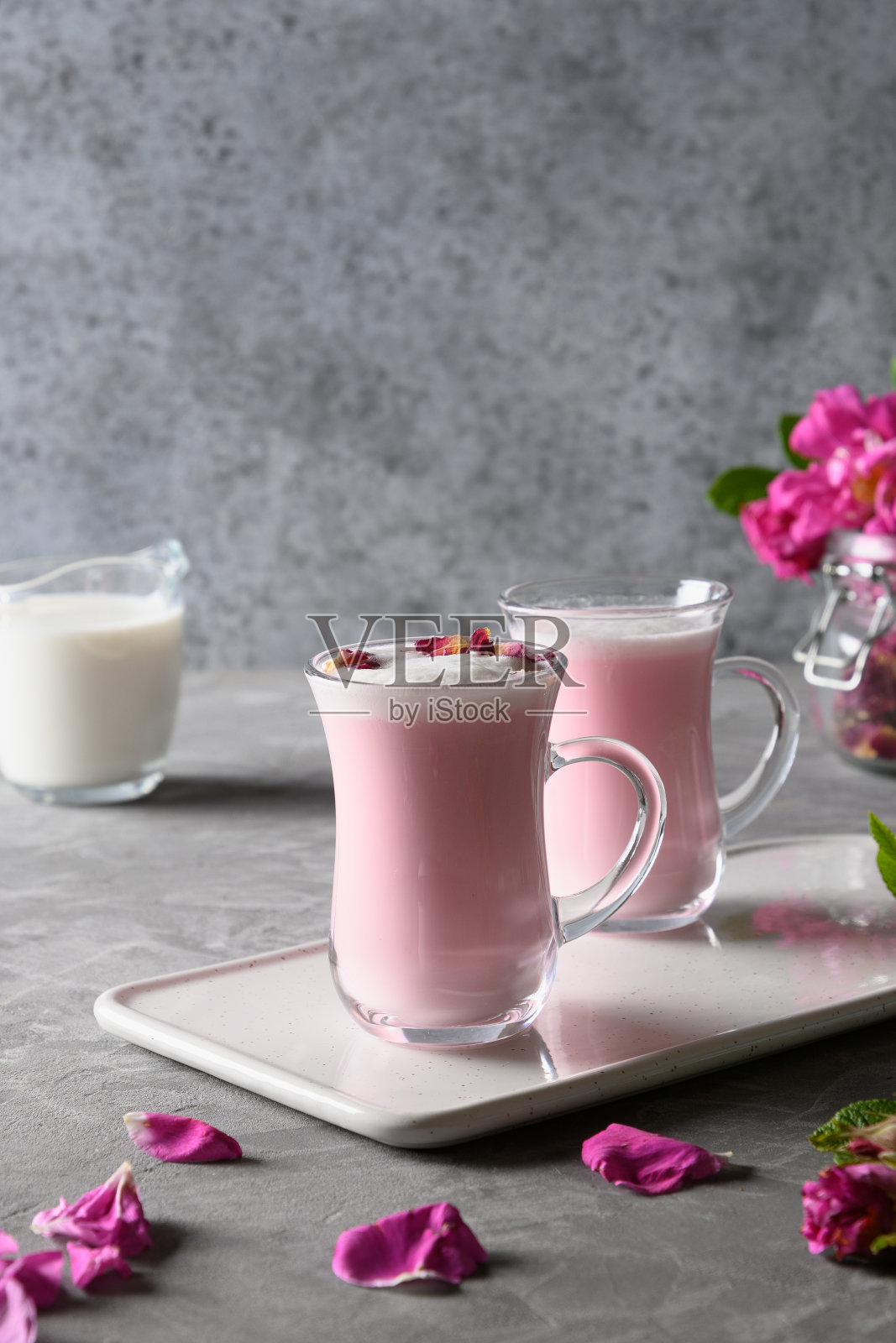 在灰色的杯子里,玫瑰月色的牛奶。照片摄影图片