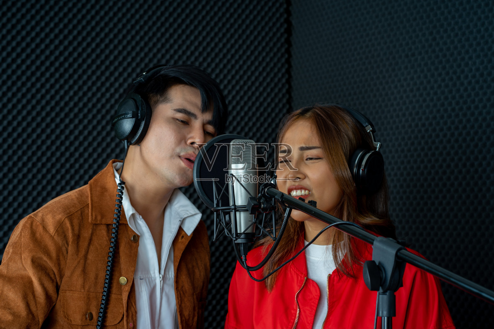 亚洲男人和女人在音乐录音棚里用麦克风吃饭照片摄影图片