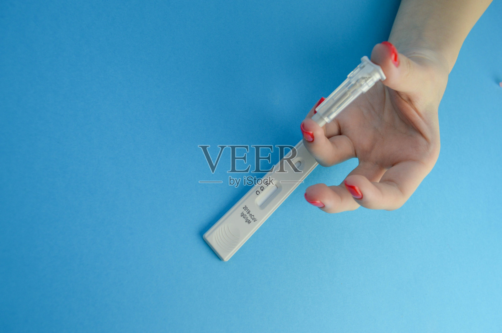 诊断冠状病毒的血液检测。在蓝色哑光背景上进行试纸和手指穿刺。IgG、IgM抗体测定照片摄影图片