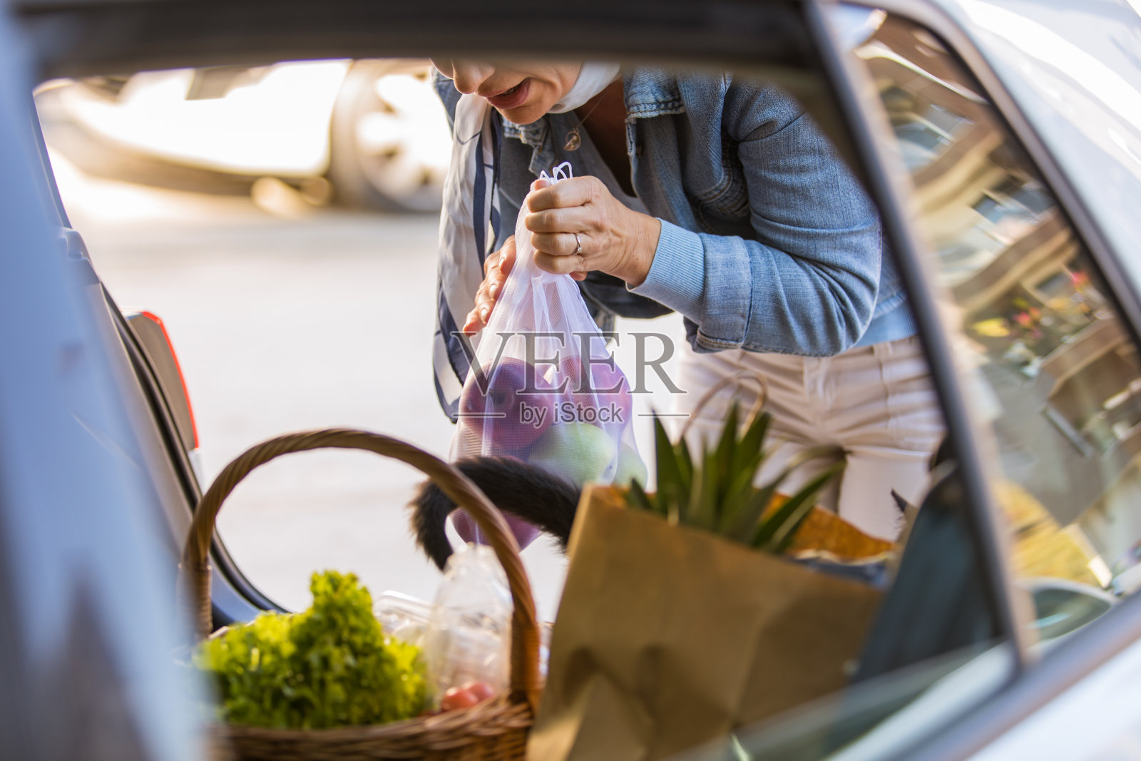 一个女人在车后备箱里装着杂货照片摄影图片