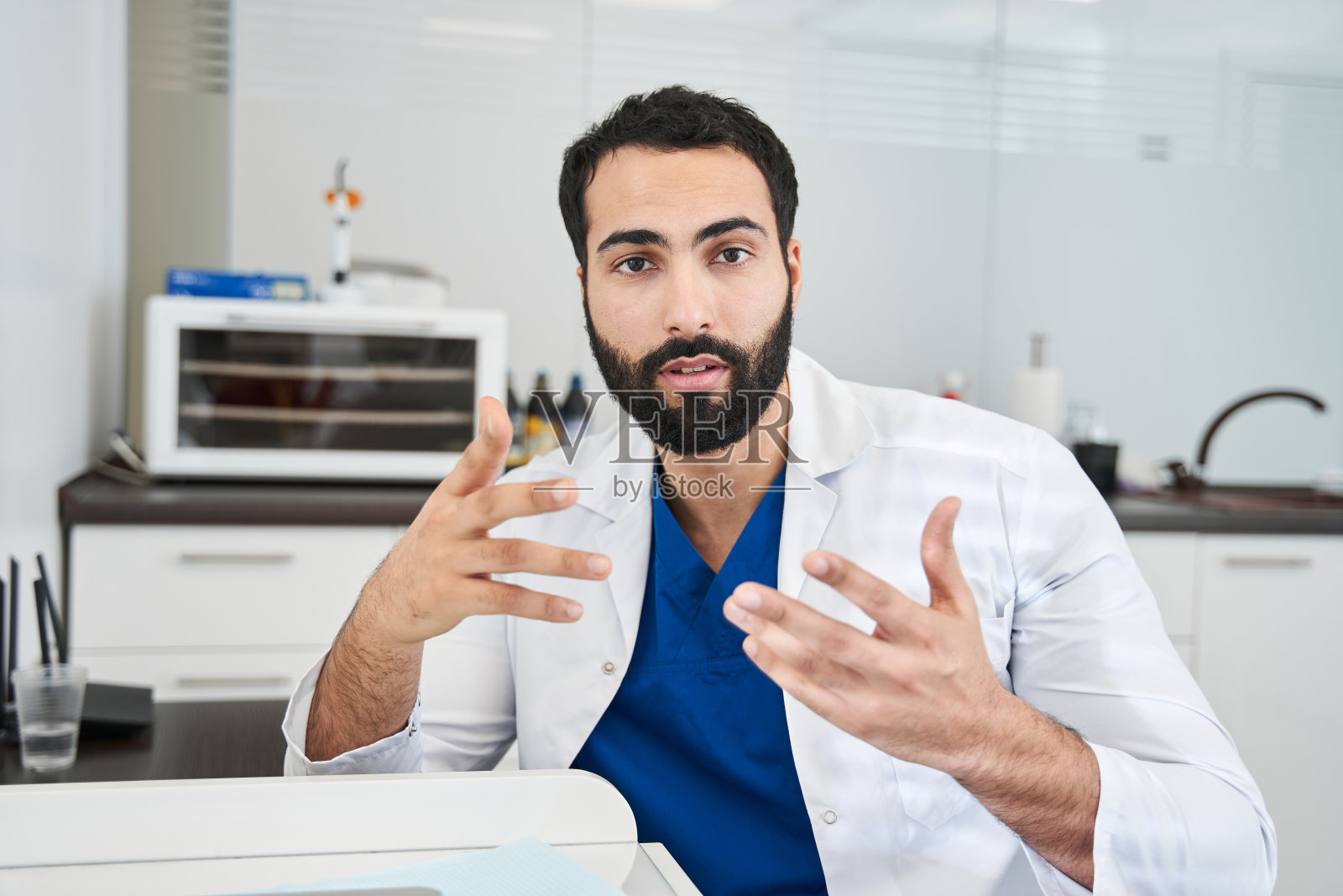 男牙医透过互联网与病人沟通照片摄影图片