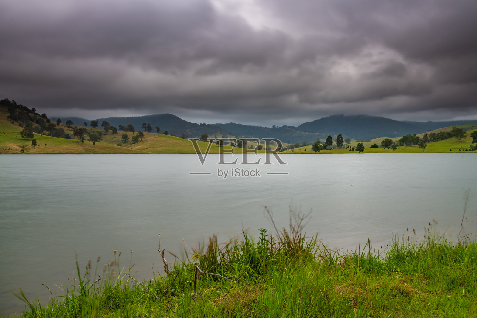 大坝被多山的乡村包围照片摄影图片