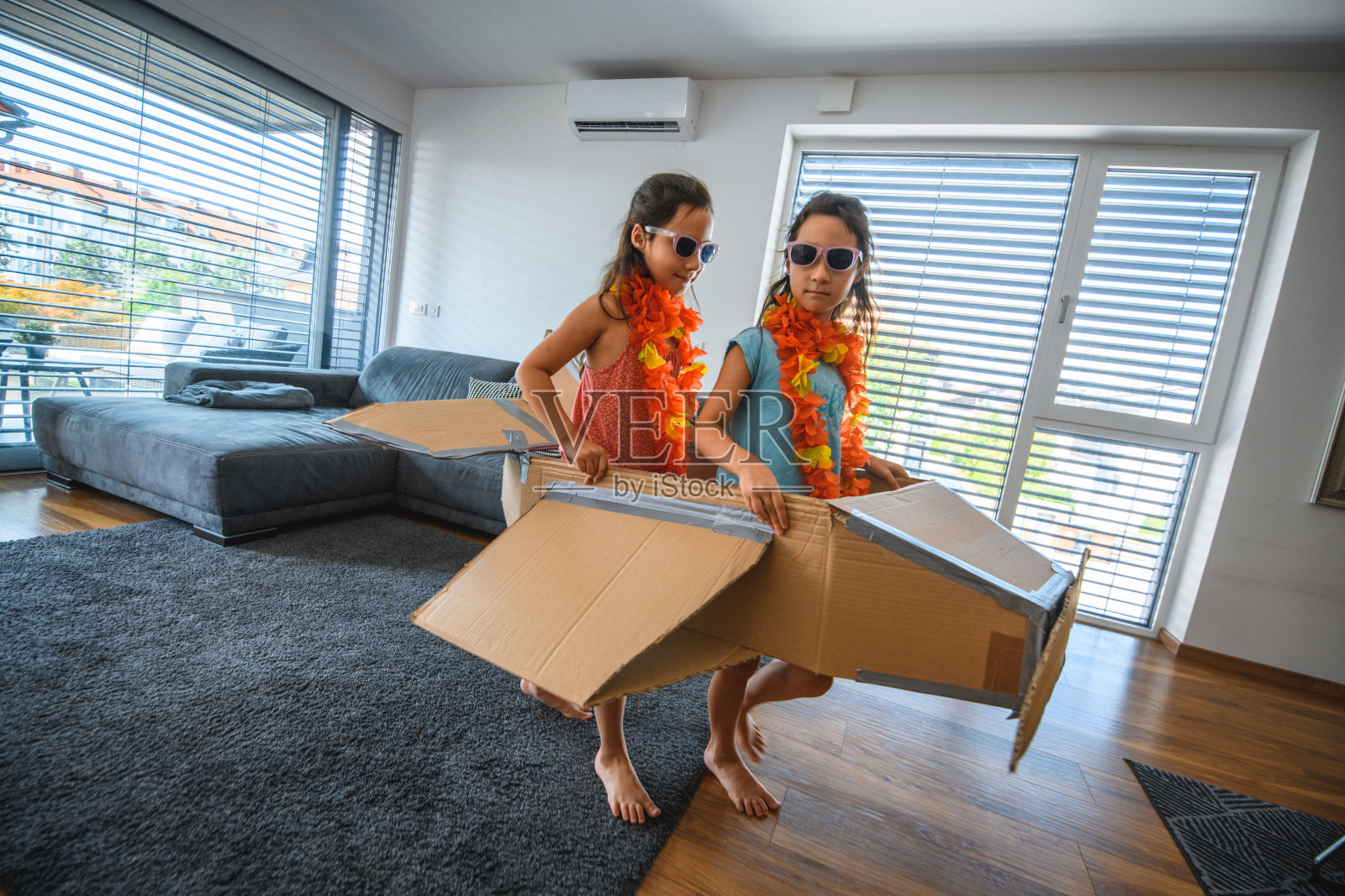 姐妹们在室内玩纸板飞机照片摄影图片