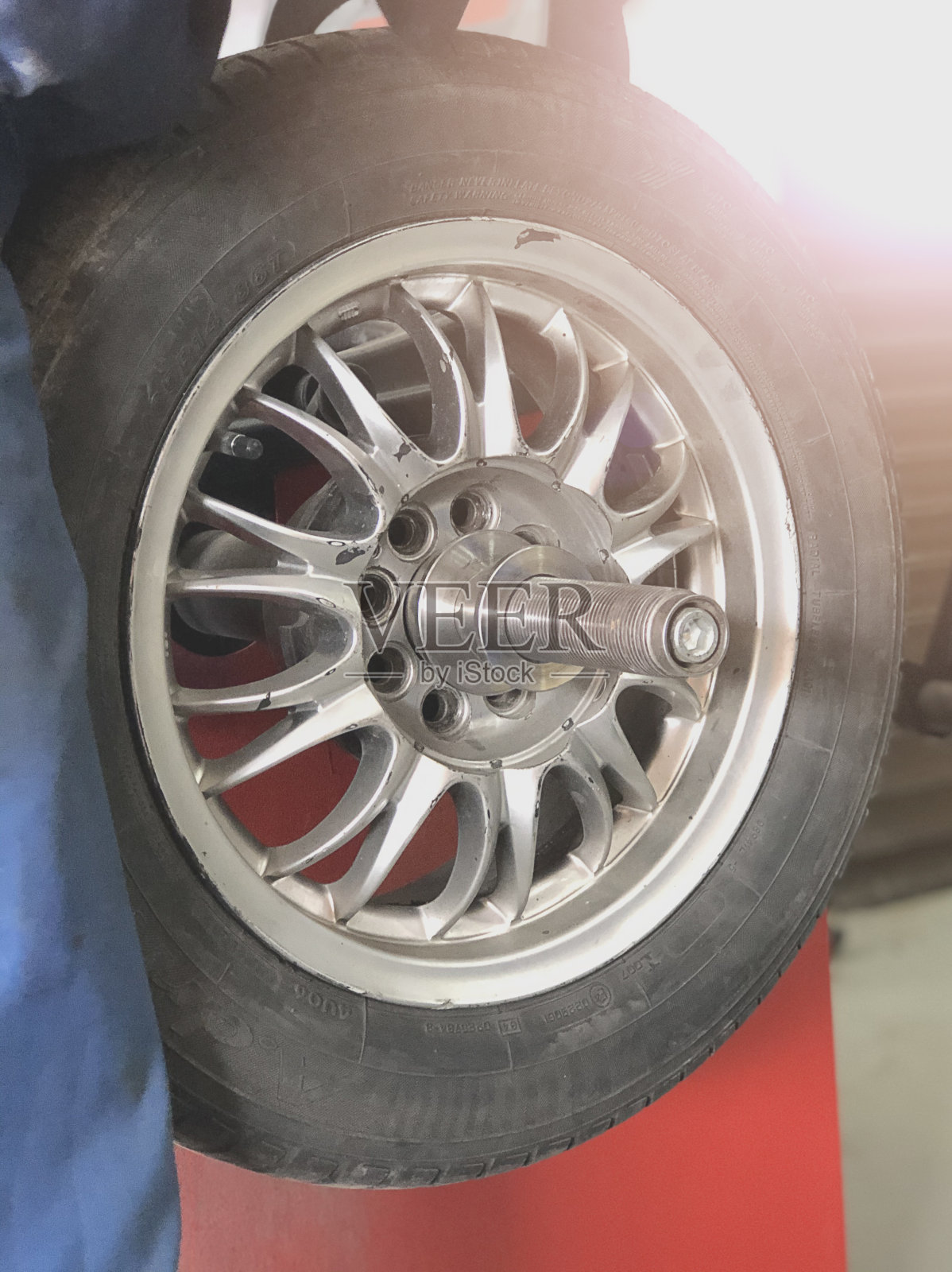 车轮平衡或修理和更换汽车轮胎在汽车修理厂或车间由机械师照片摄影图片