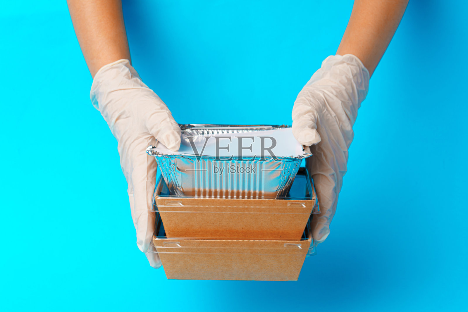 送餐员递上食物容器和包裹照片摄影图片