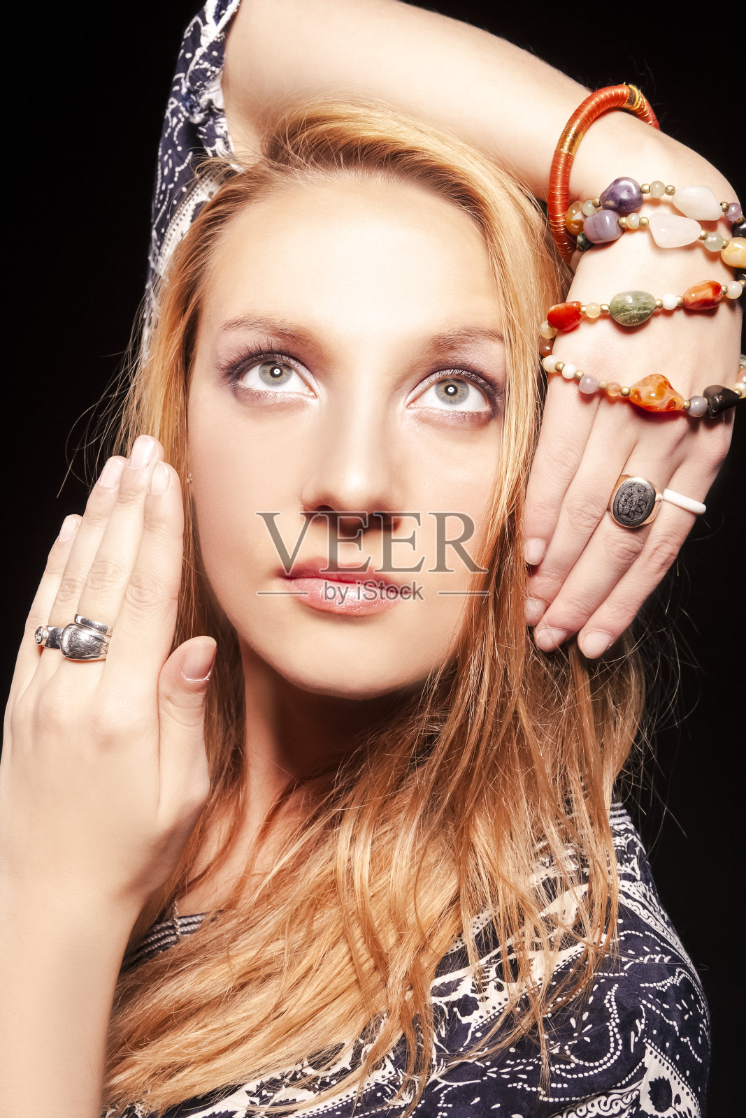 平静的白种人金发女孩的肖像,双手合十。在黑色背景下的工作室里摆姿势。垂直的图像照片摄影图片