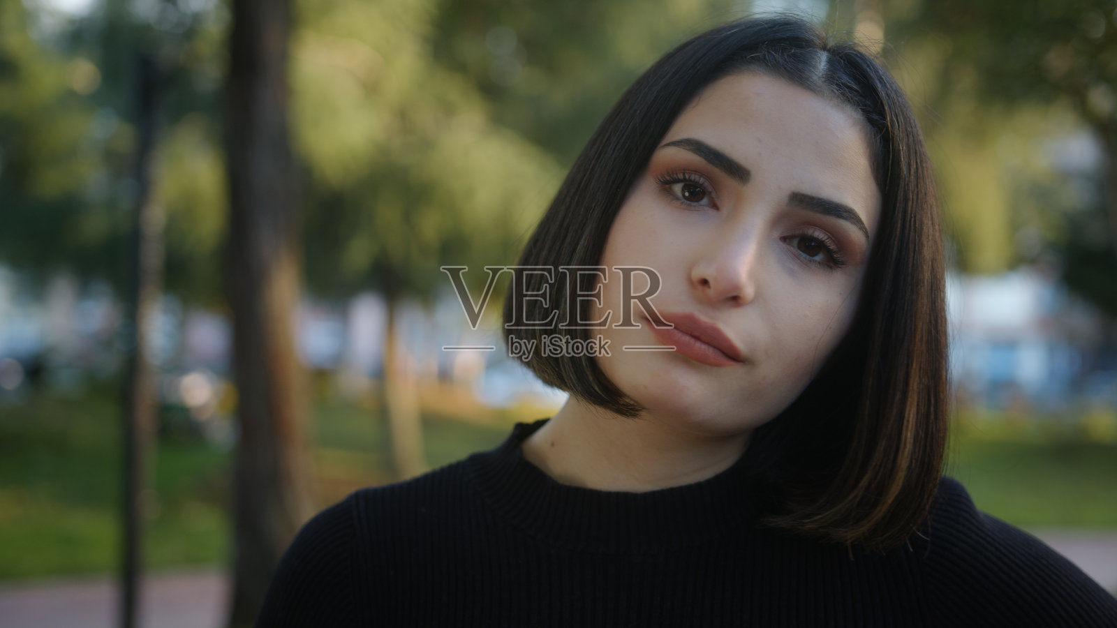 年轻漂亮的女人看着镜头,一副无聊的样子照片摄影图片