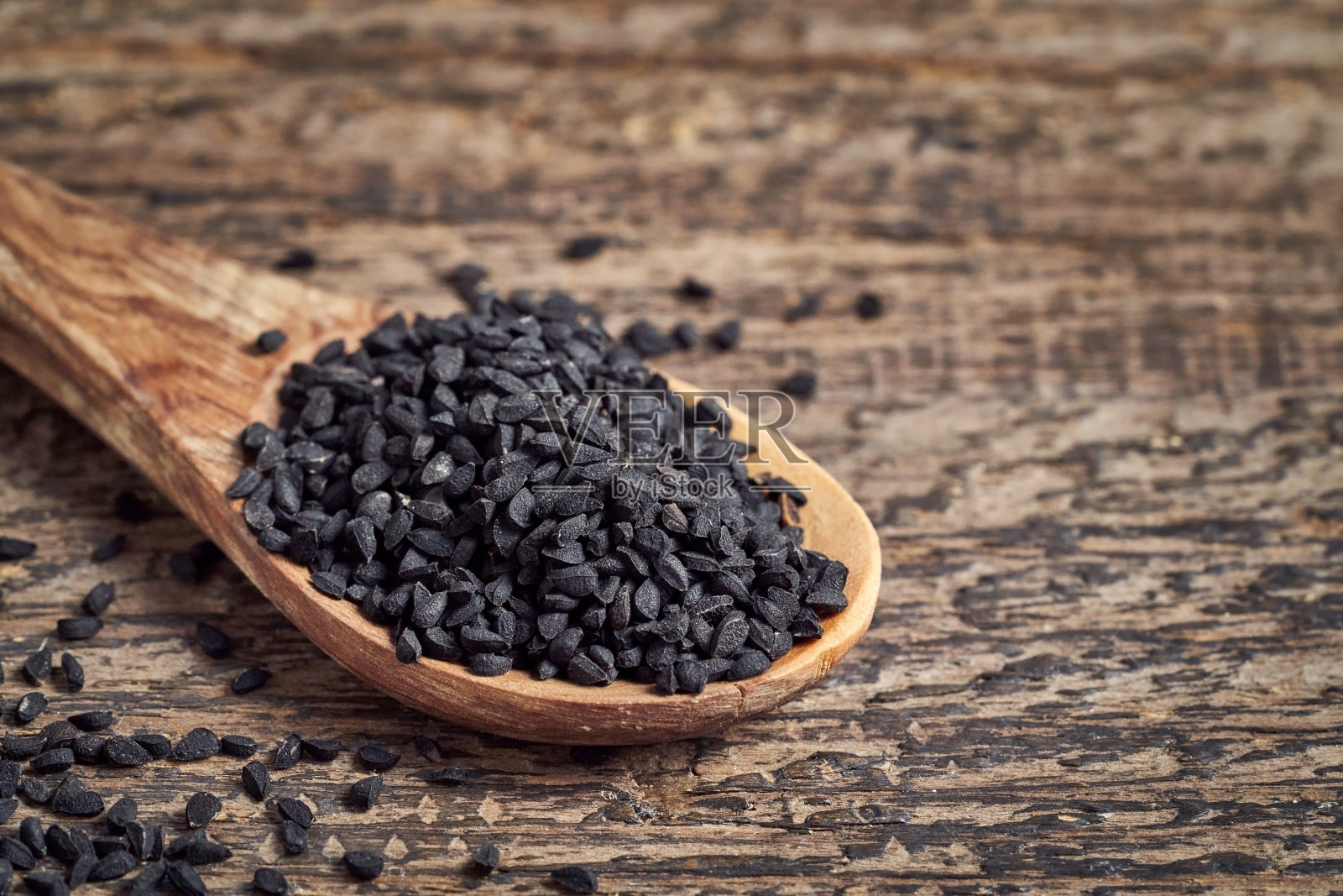 木勺上放黑色孜然籽照片摄影图片