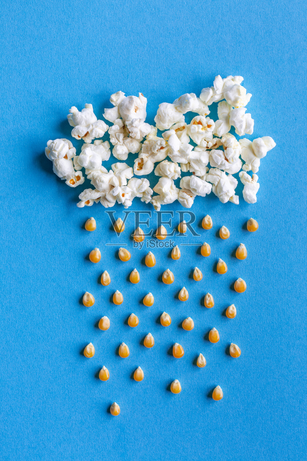 大爆米花云与雨由玉米粒制成的蓝色背景与复制空间照片摄影图片
