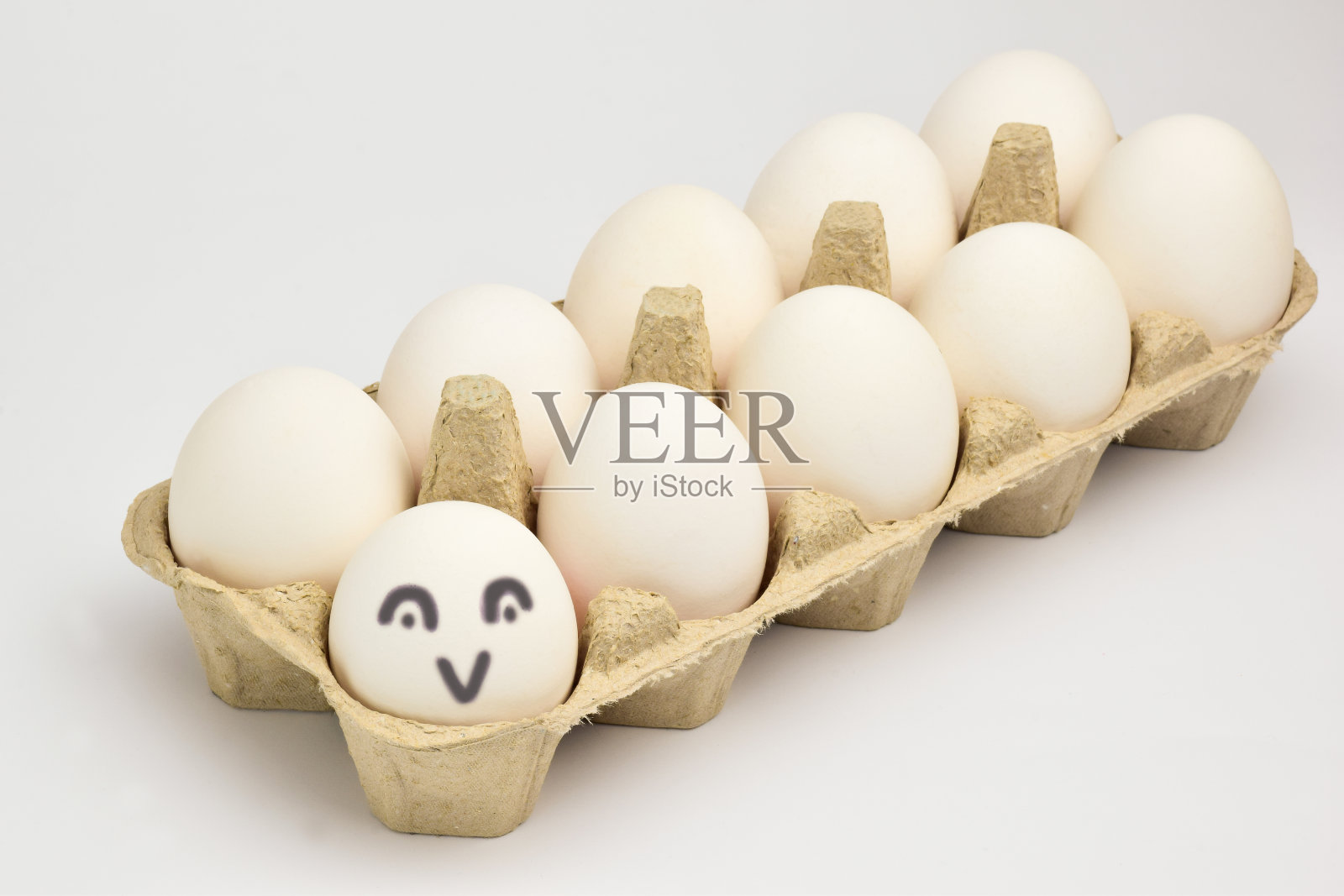 这是一盘10个白鸡蛋的特写。第一个蛋有一个微笑照片摄影图片