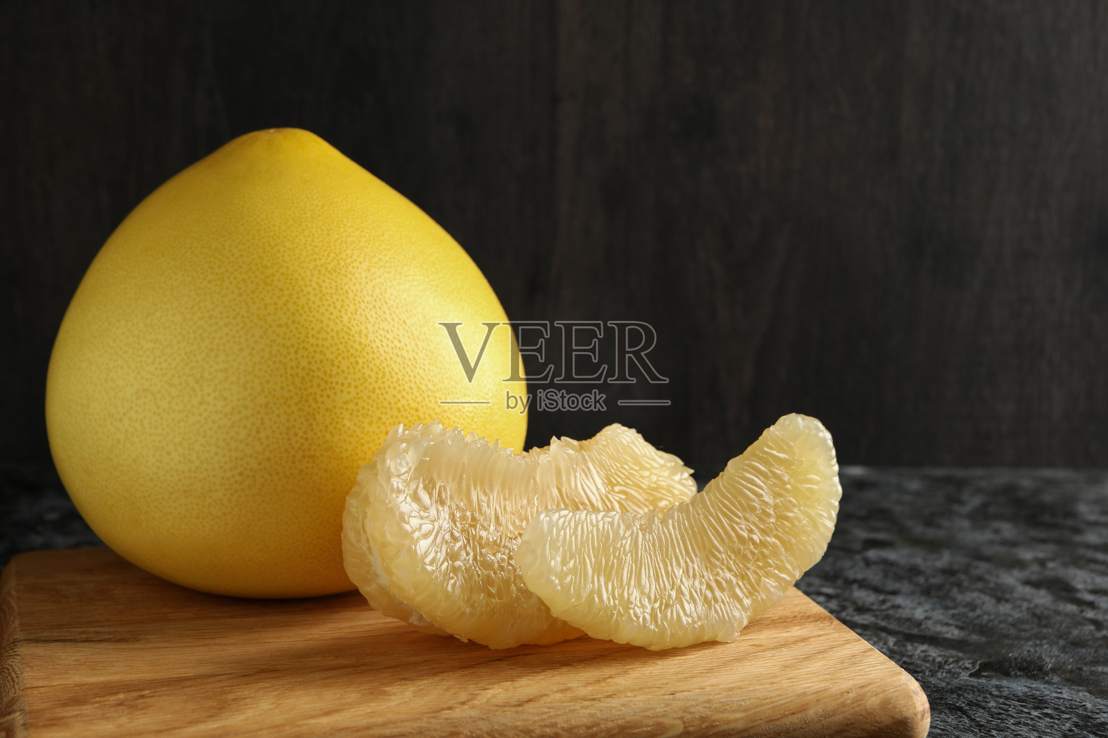 在黑烟熏的桌子上放着成熟的柚子照片摄影图片