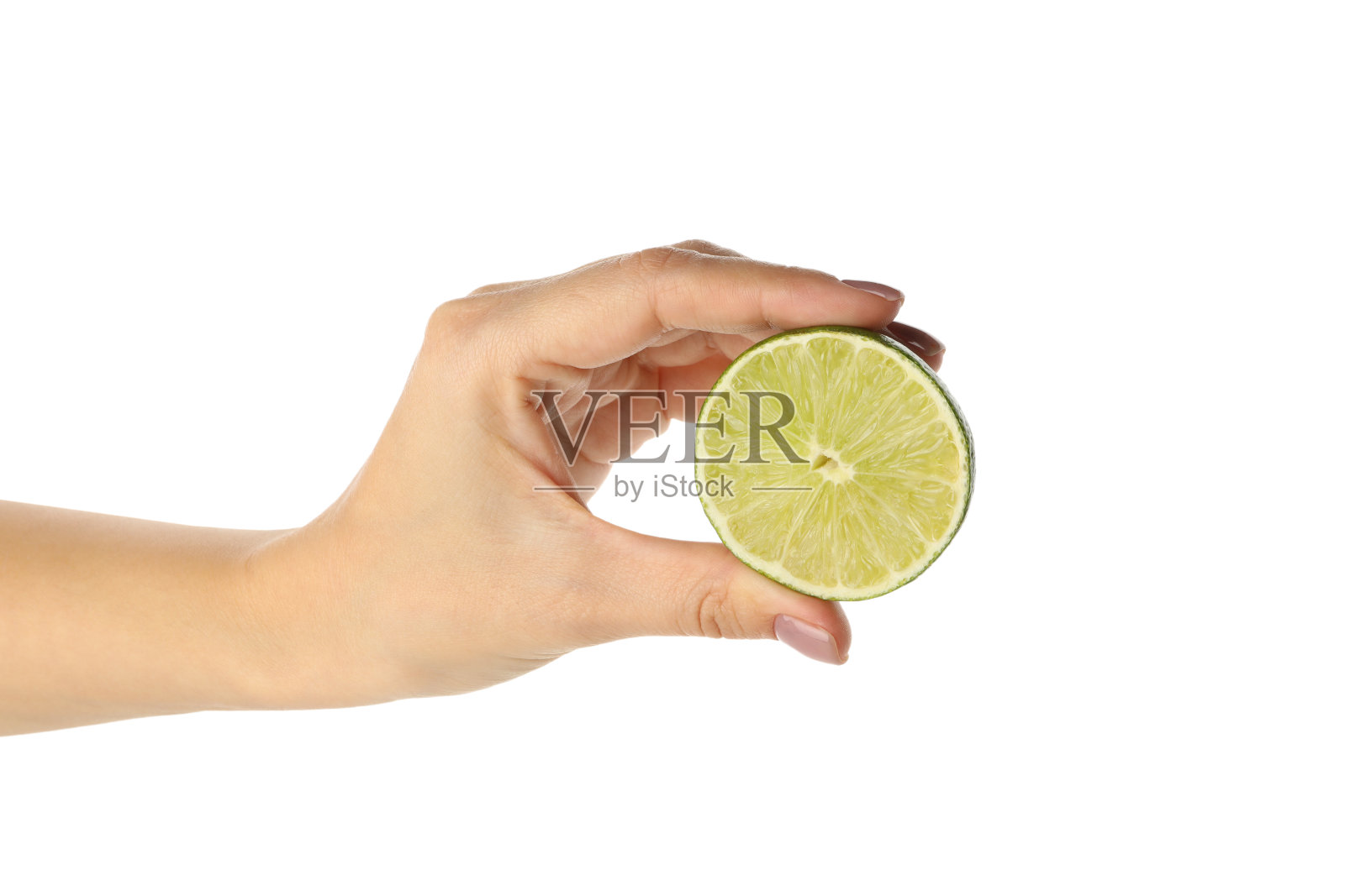 女性手中握着一半的石灰,孤立在白色的背景上照片摄影图片