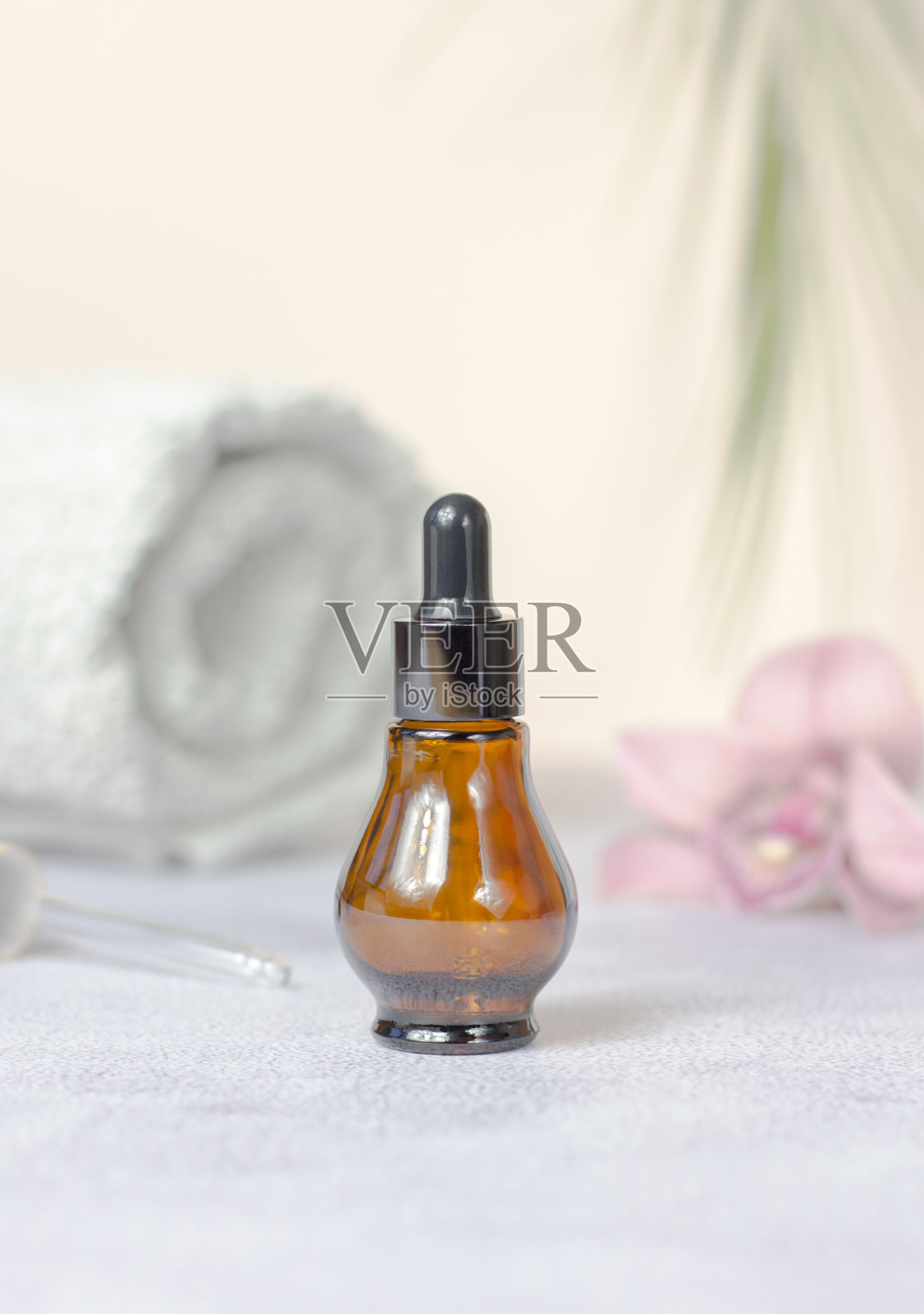 美容水疗概念。天然石材、兰花花、卷白毛巾、精油瓶组成。照片摄影图片