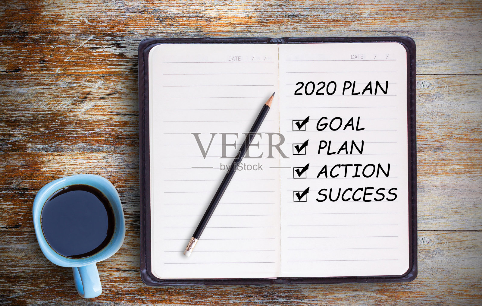 把2020计划和咖啡杯、笔记本、铅笔放在脏兮兮的木桌上。照片摄影图片