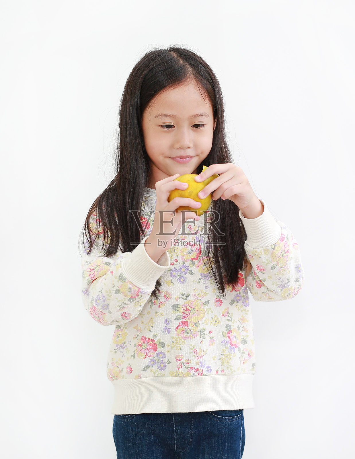 小亚洲女孩的肖像剥橙色在白色的背景照片摄影图片