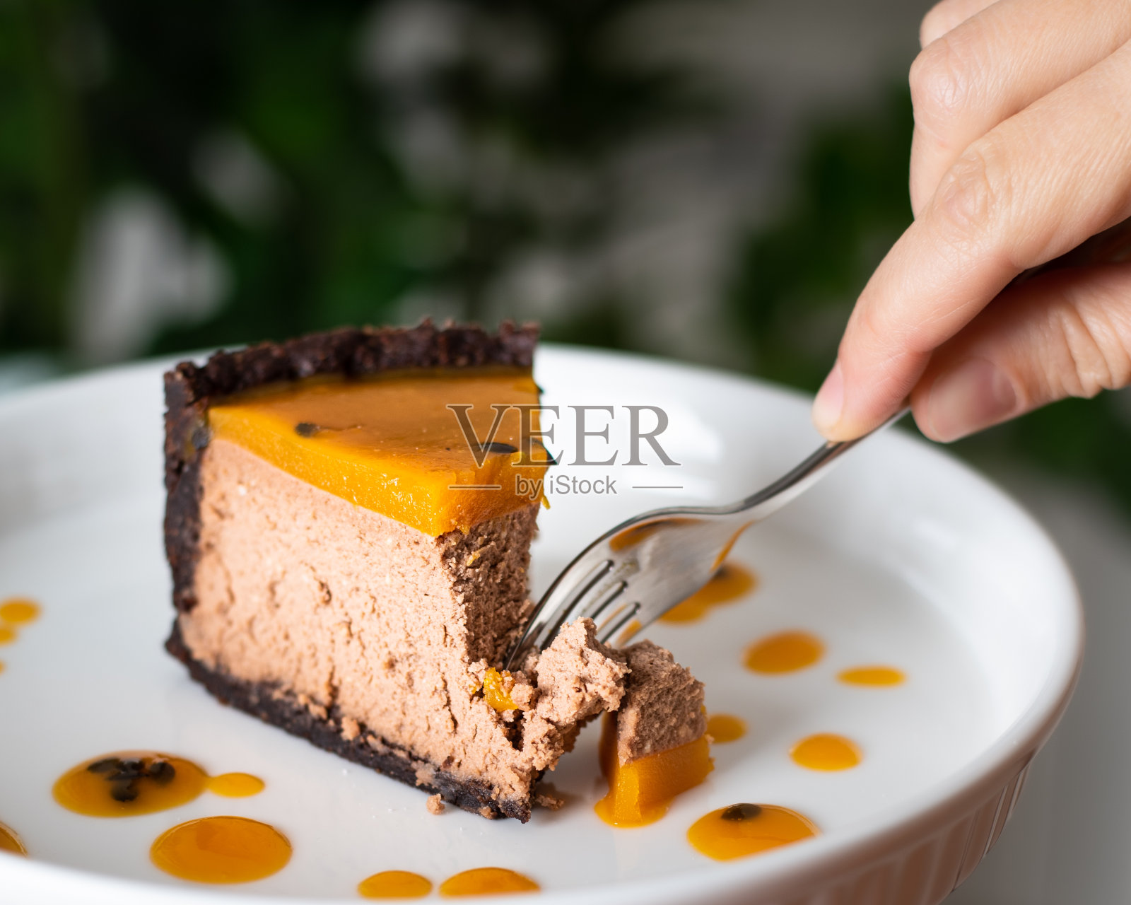 巧克力芝士蛋糕配芒果和百香果。一片芒果。照片摄影图片