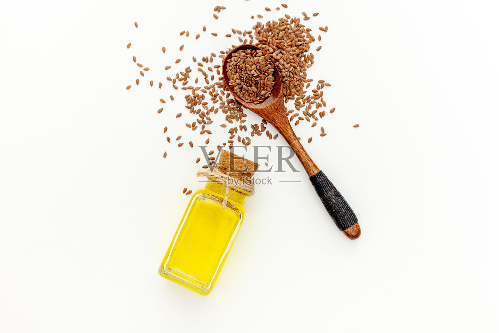用勺子和碗盛亚麻籽,再加一瓶亚麻籽油照片摄影图片