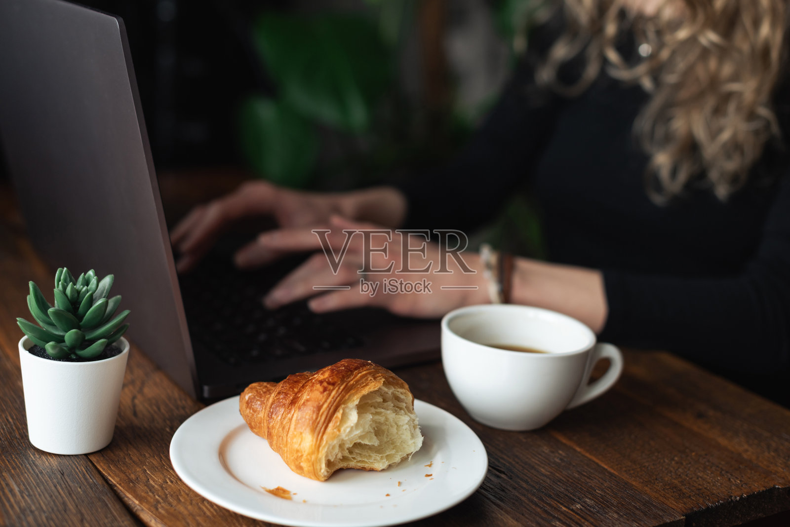 一个面目全非的自由职业者在咖啡馆用笔记本电脑工作照片摄影图片