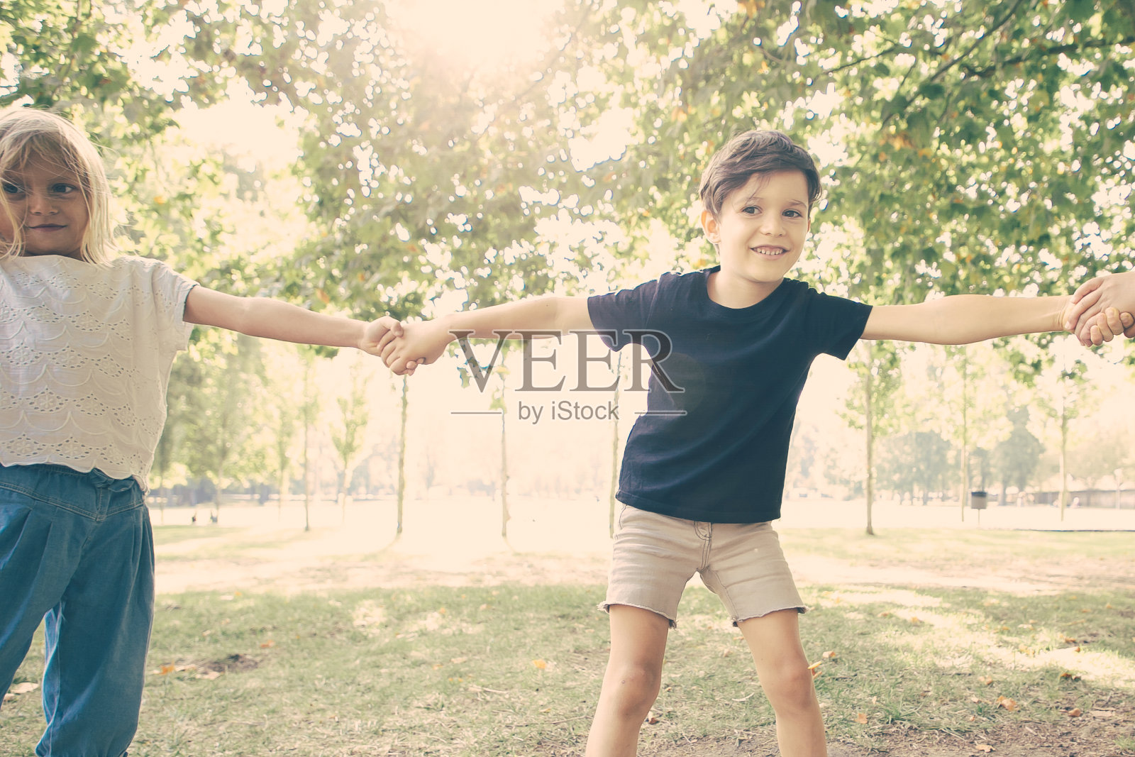 快乐的男孩和朋友在公园里玩照片摄影图片