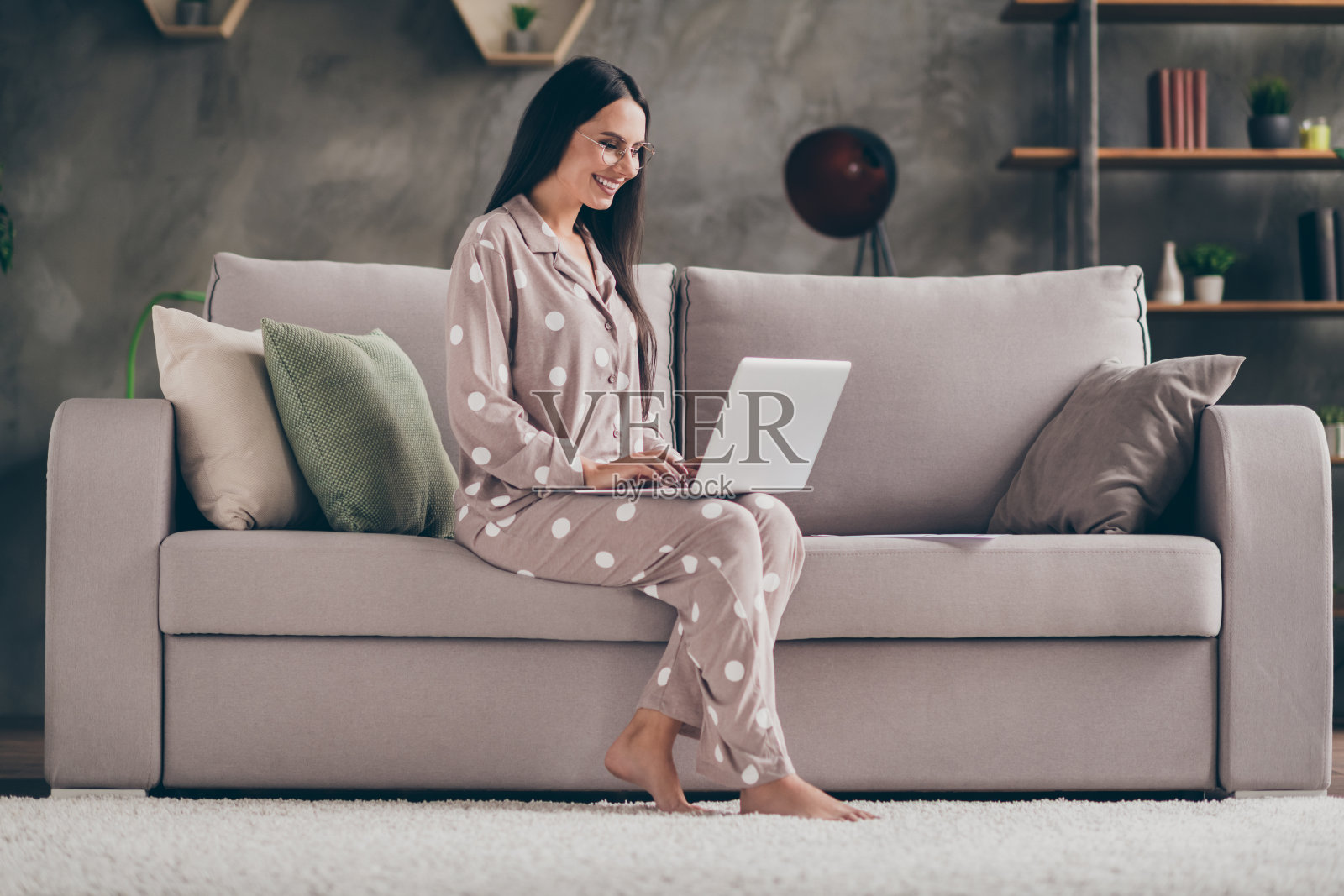 资料照片的好乐观的女孩坐写笔记本电脑戴眼镜睡在家里的沙发上照片摄影图片