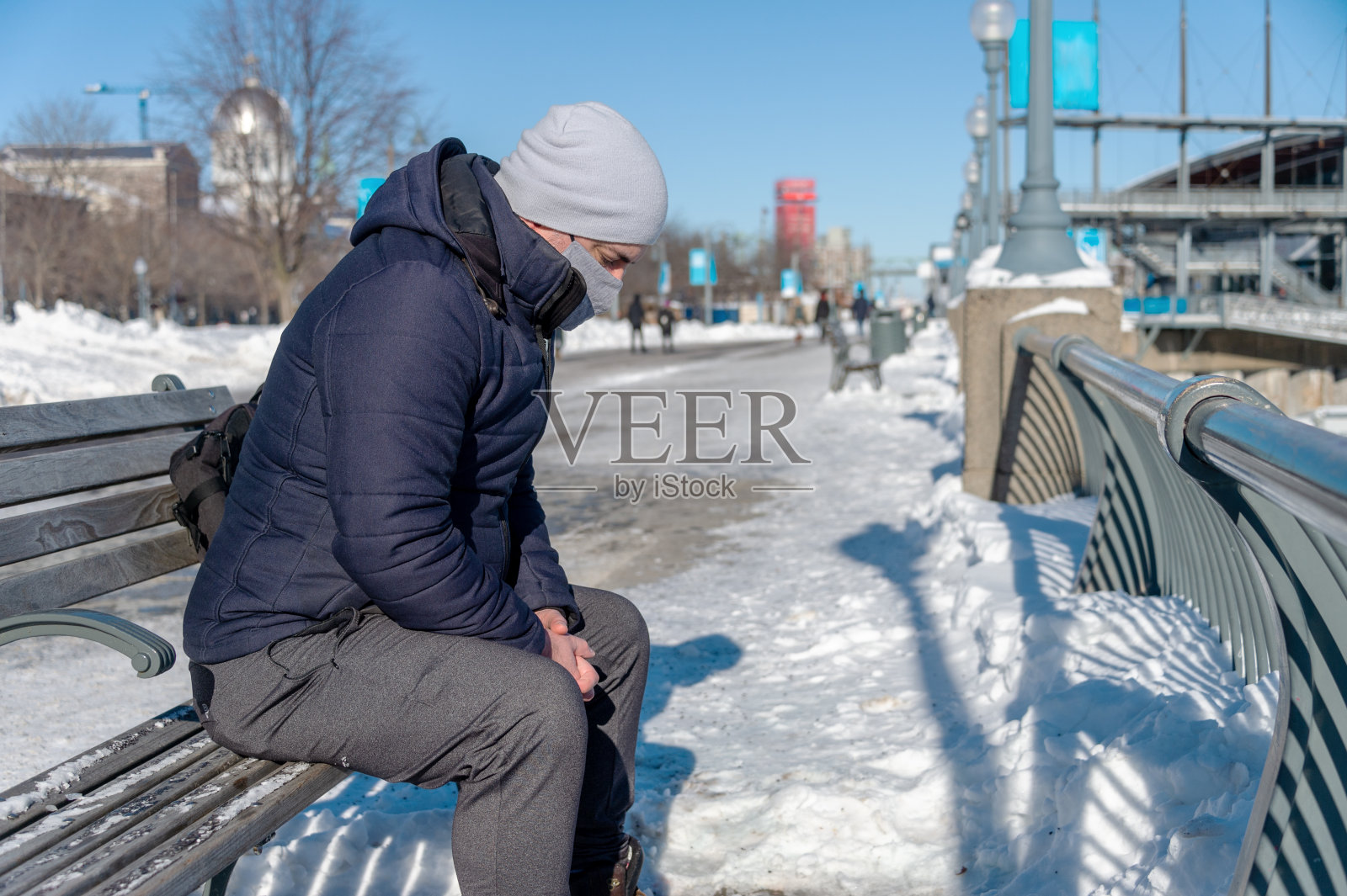 疫情期间戴防护口罩坐在长椅上的男人照片摄影图片