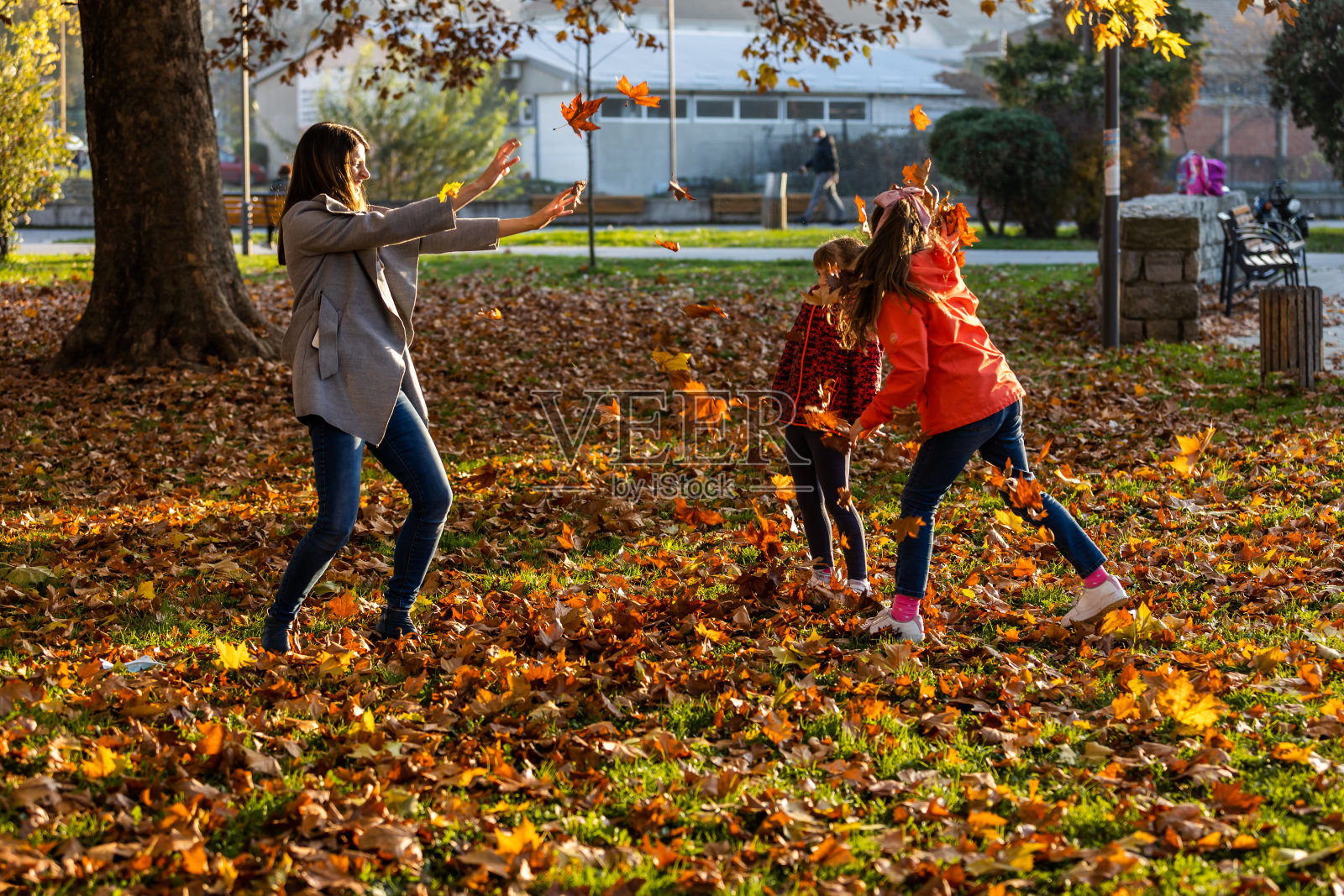 一位母亲和她的女儿们在享受秋天的游戏照片摄影图片