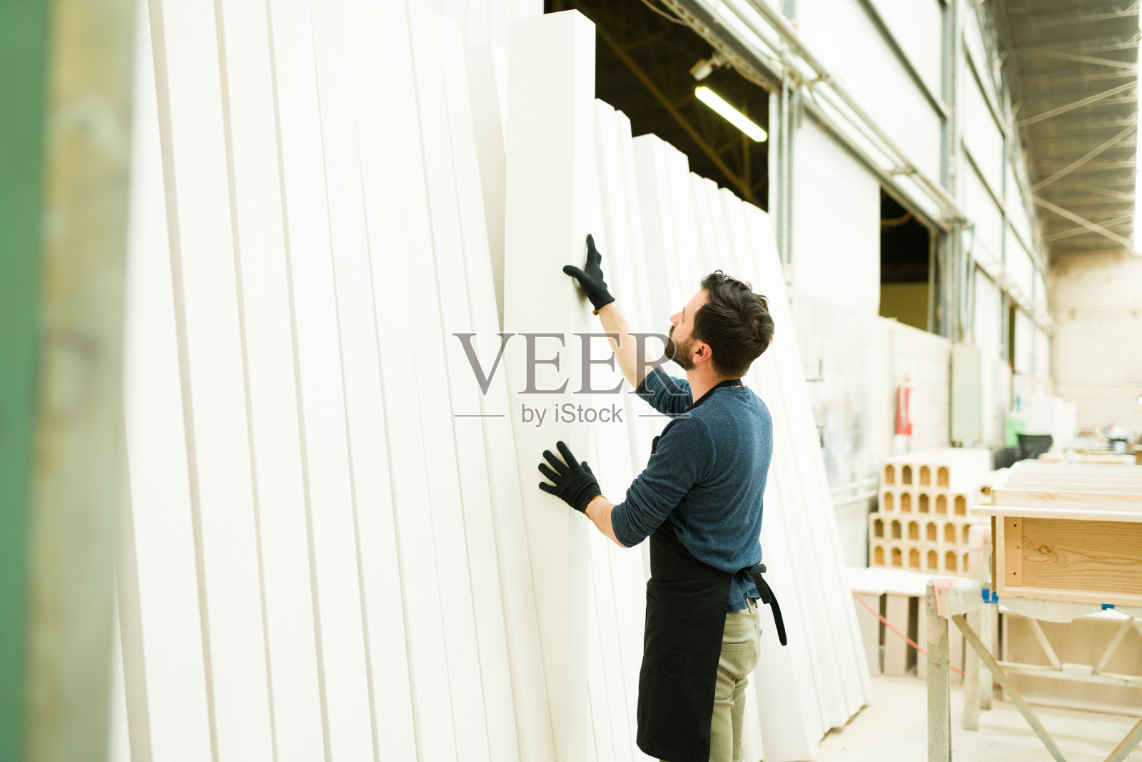 一名男性工人选择木梁的后视图照片摄影图片