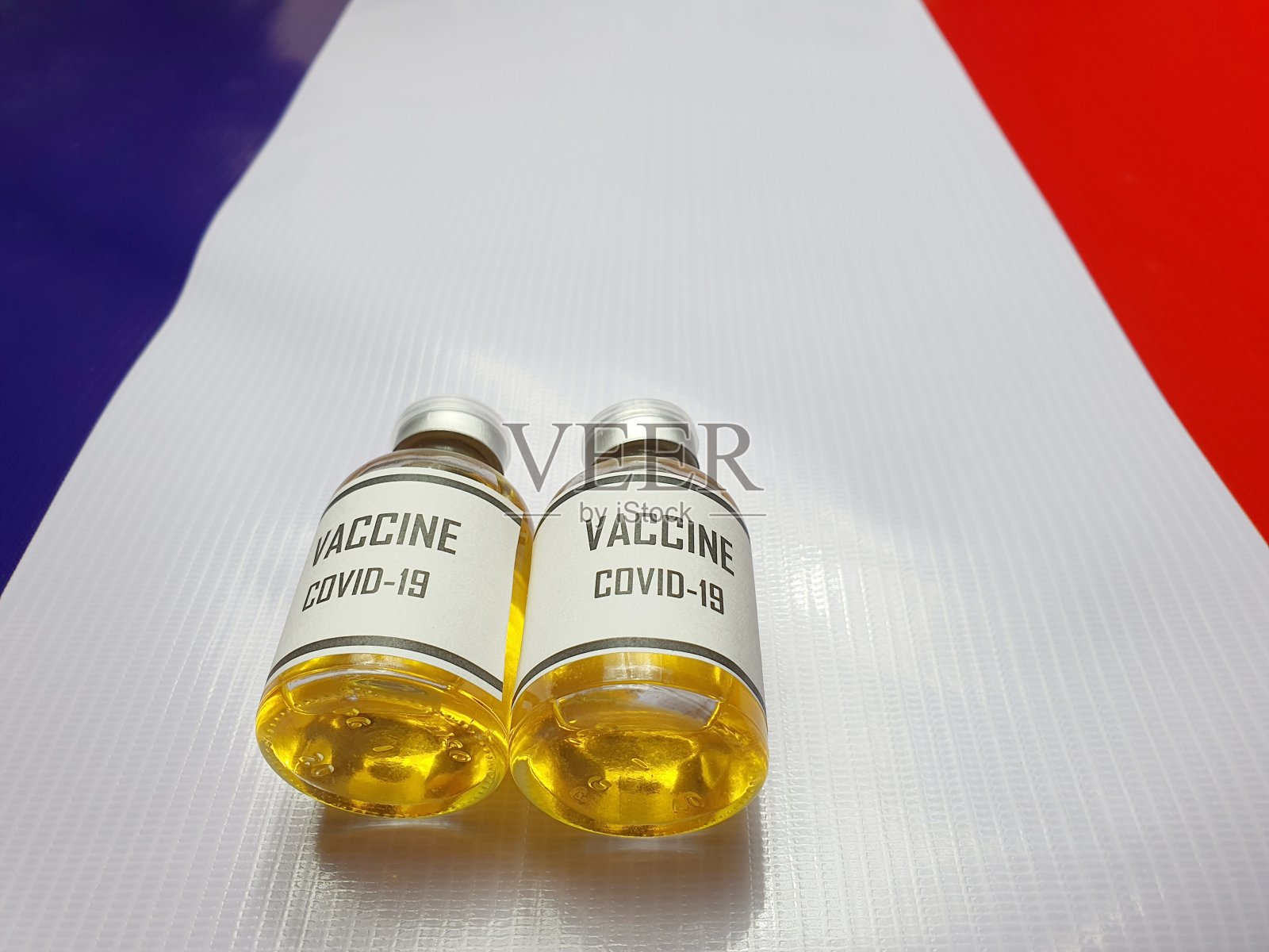 一个抗COVID-19疫苗瓶被放置在法国国旗上。使用作为一个网站横幅背景,背景照片摄影图片