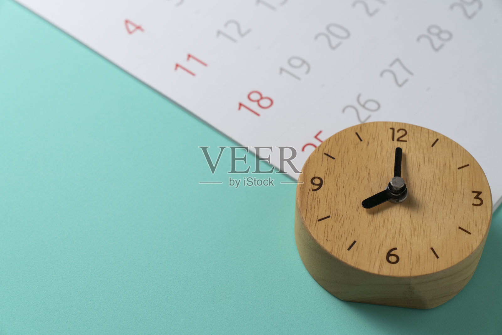 近距离的日历和闹钟放在绿色桌子的背景上,规划商务会议或旅行的规划概念照片摄影图片