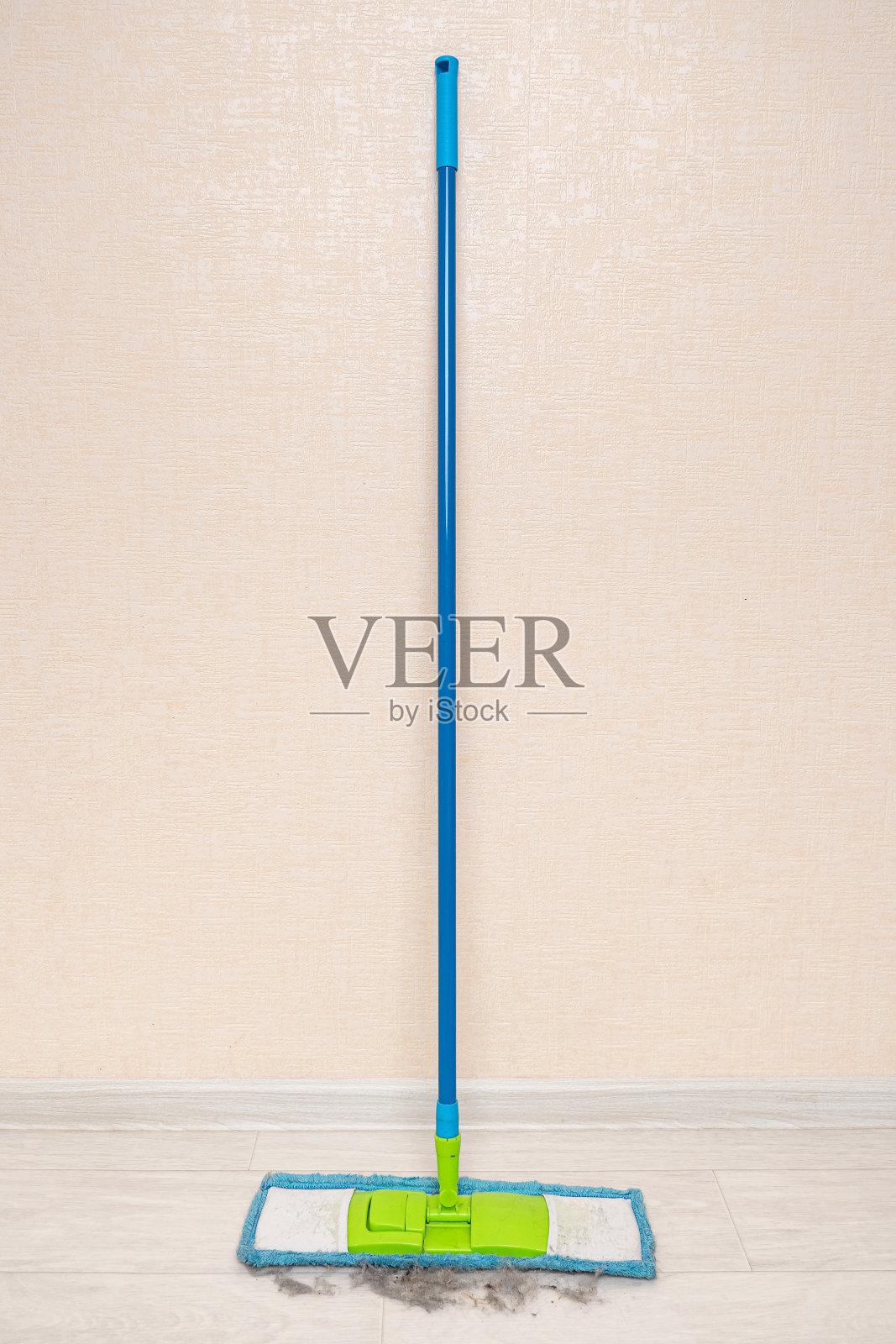 蓝色拖把靠墙放着,地上有收集的垃圾照片摄影图片