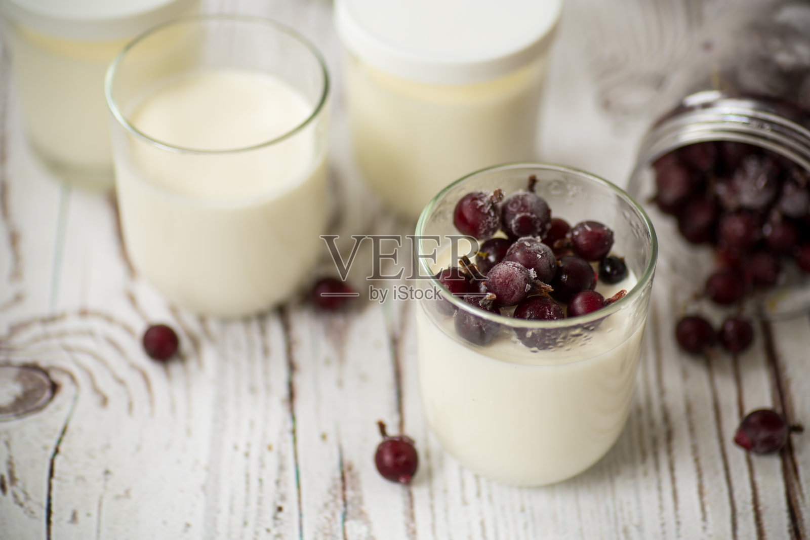 用玻璃杯装着冰冻浆果的自制甜酸奶照片摄影图片