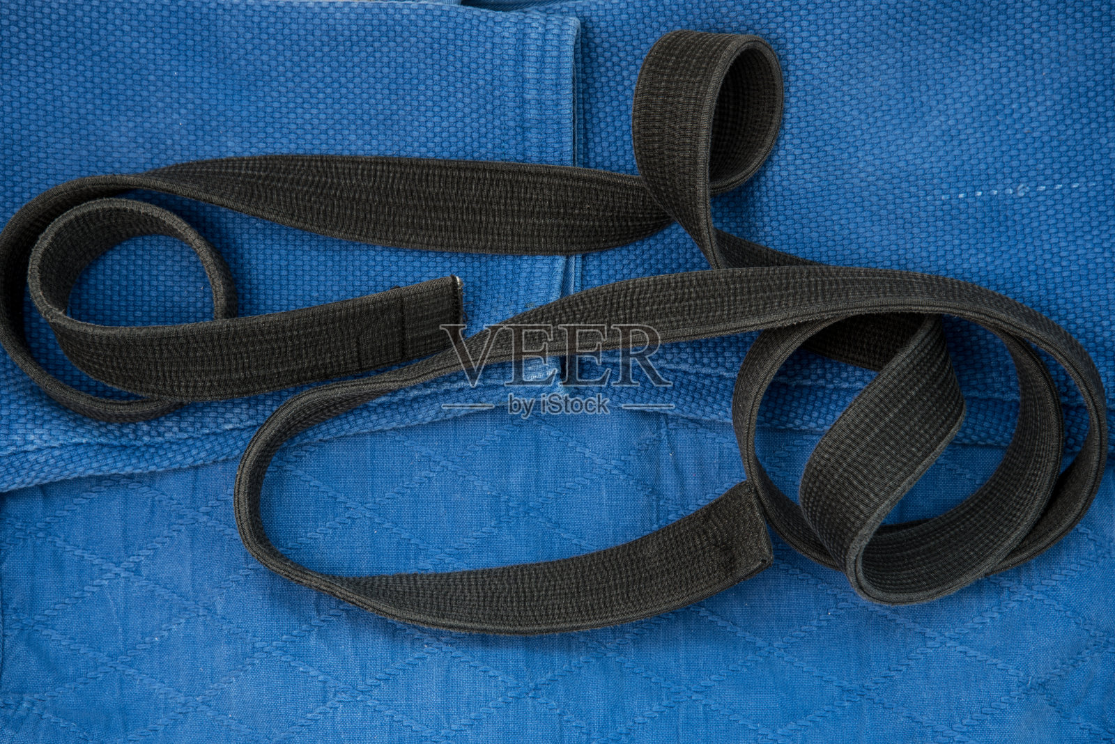 从上往下看。柔道课穿和服,黑带。和服是蓝色的。背景纹理。照片摄影图片