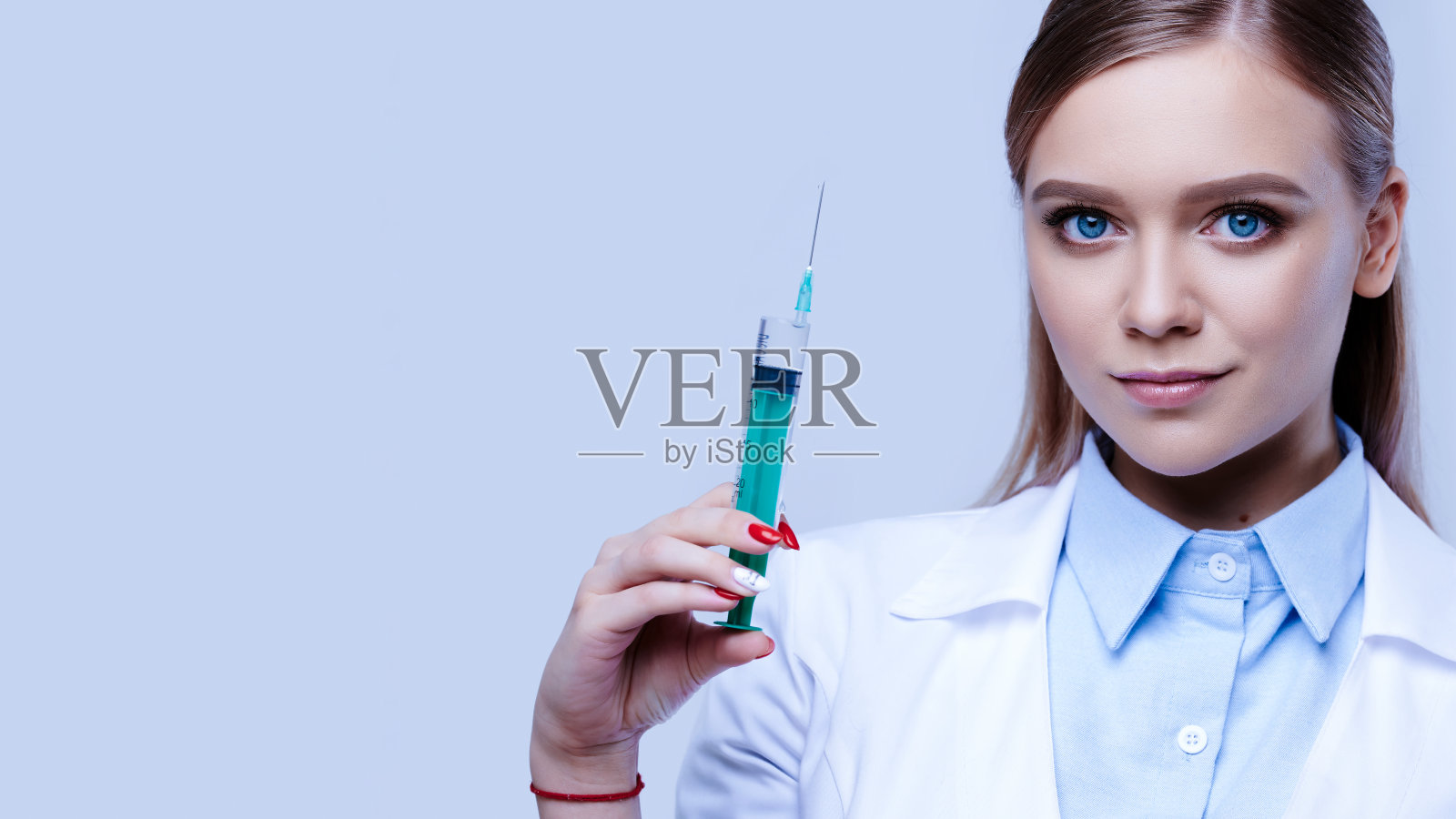 身穿制服手持注射器的女医生,年轻护士,医院工作人员照片摄影图片