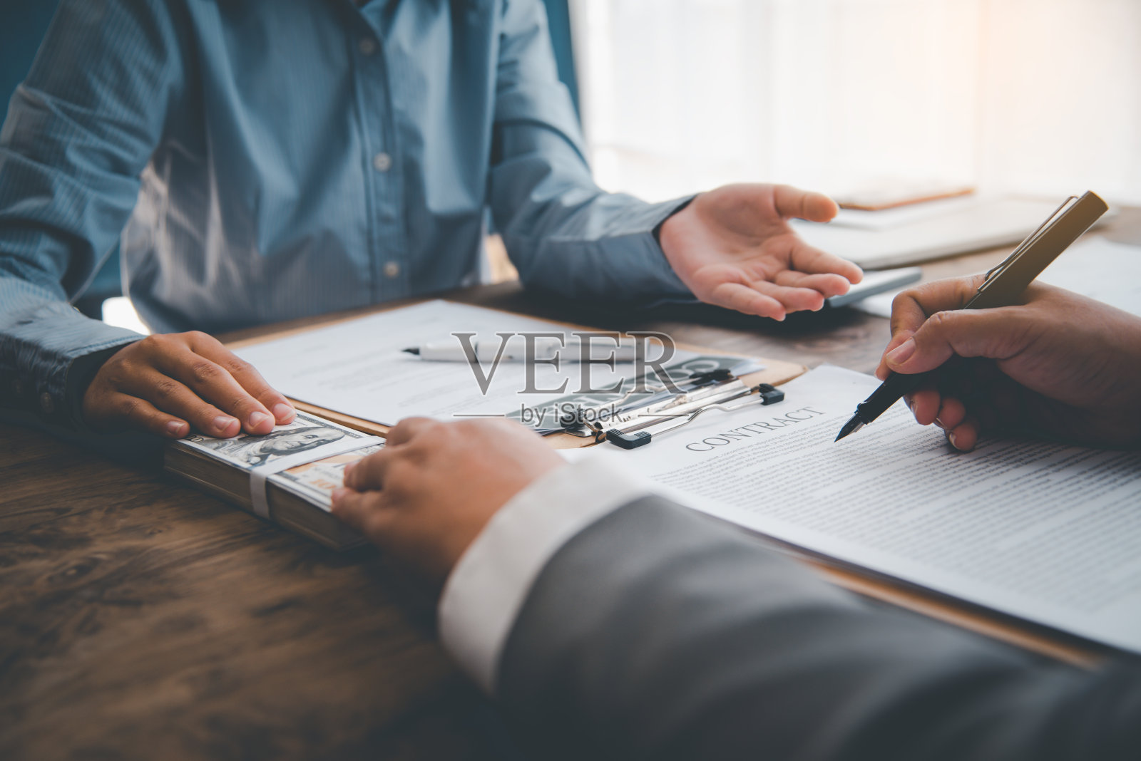 一名商人正在谈判一项协议,在该协议中,美元被视为腐败中的贿赂。反贿赂和腐败观念照片摄影图片