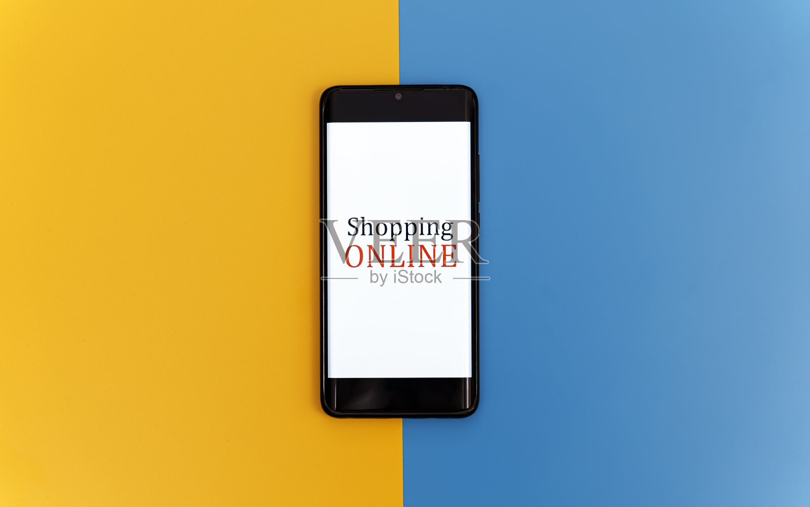 黄蓝背景的智能手机。网上购物的概念。照片摄影图片