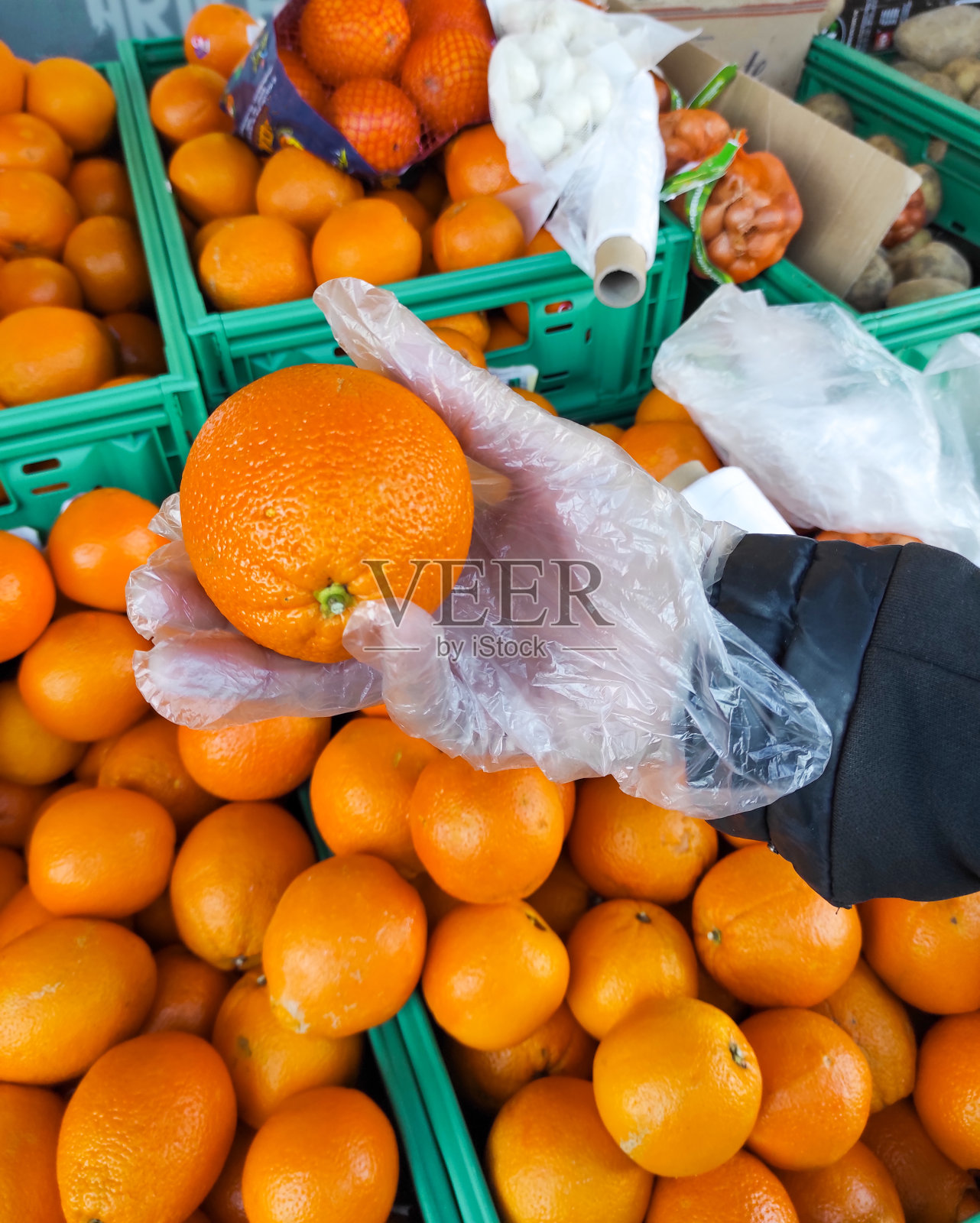 去杂货店买戴手套的橘子照片摄影图片