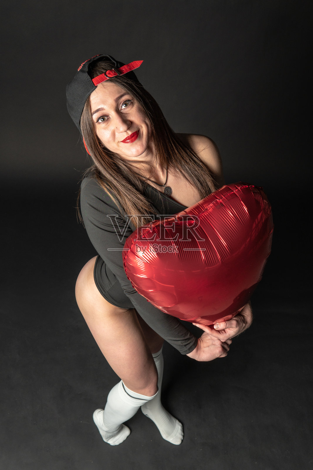 健身女性健身房黑色。穿着黑色的游泳衣。快乐,生活的姿态。运动员的臀部,躯干身体。情人节快乐照片摄影图片