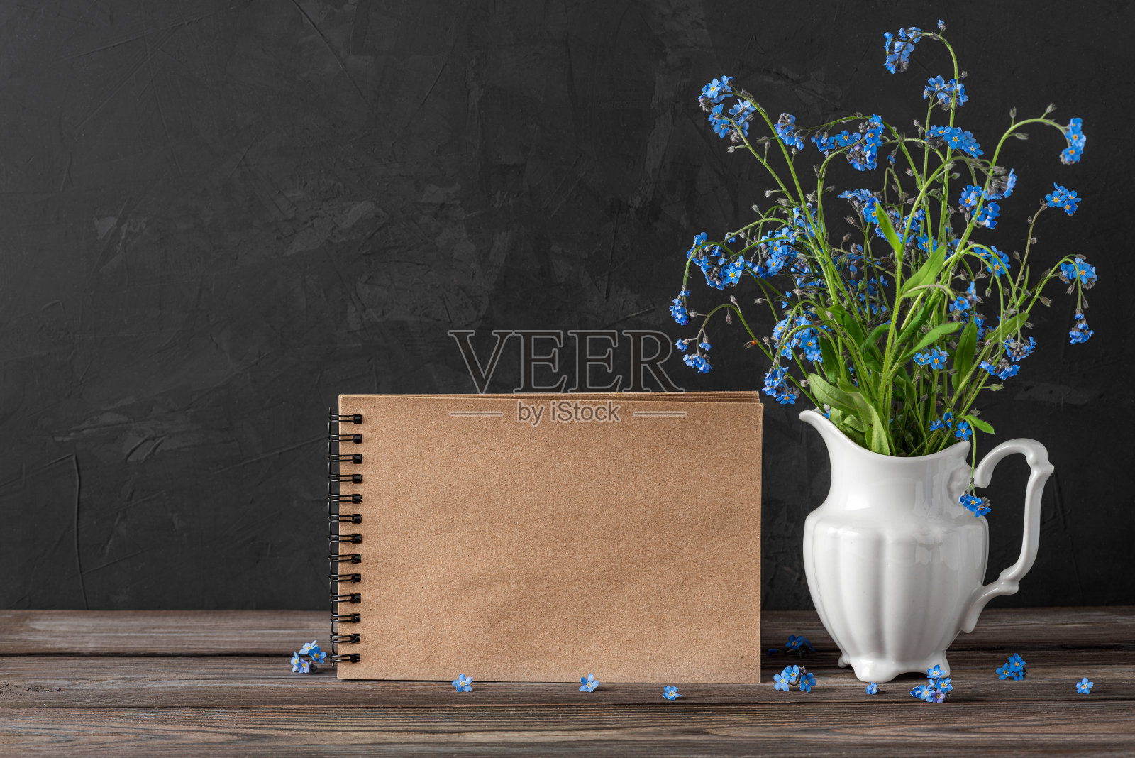 静物与勿忘我花花束在花瓶和空白贺卡在黑暗的背景与复制空间照片摄影图片