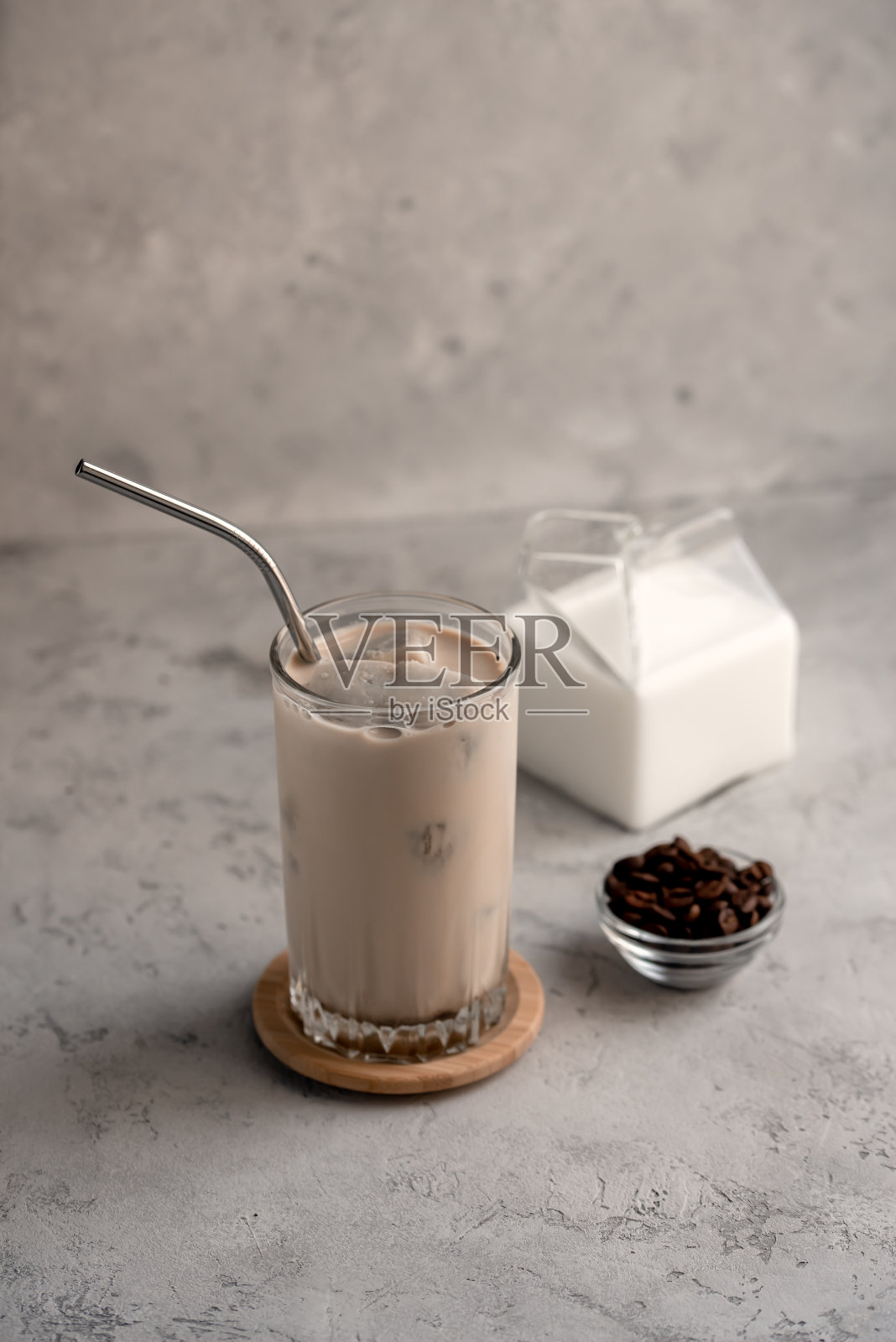 在灰色的石头背景上,用冰块冰冻的咖啡制成的奶昔的静物。照片摄影图片