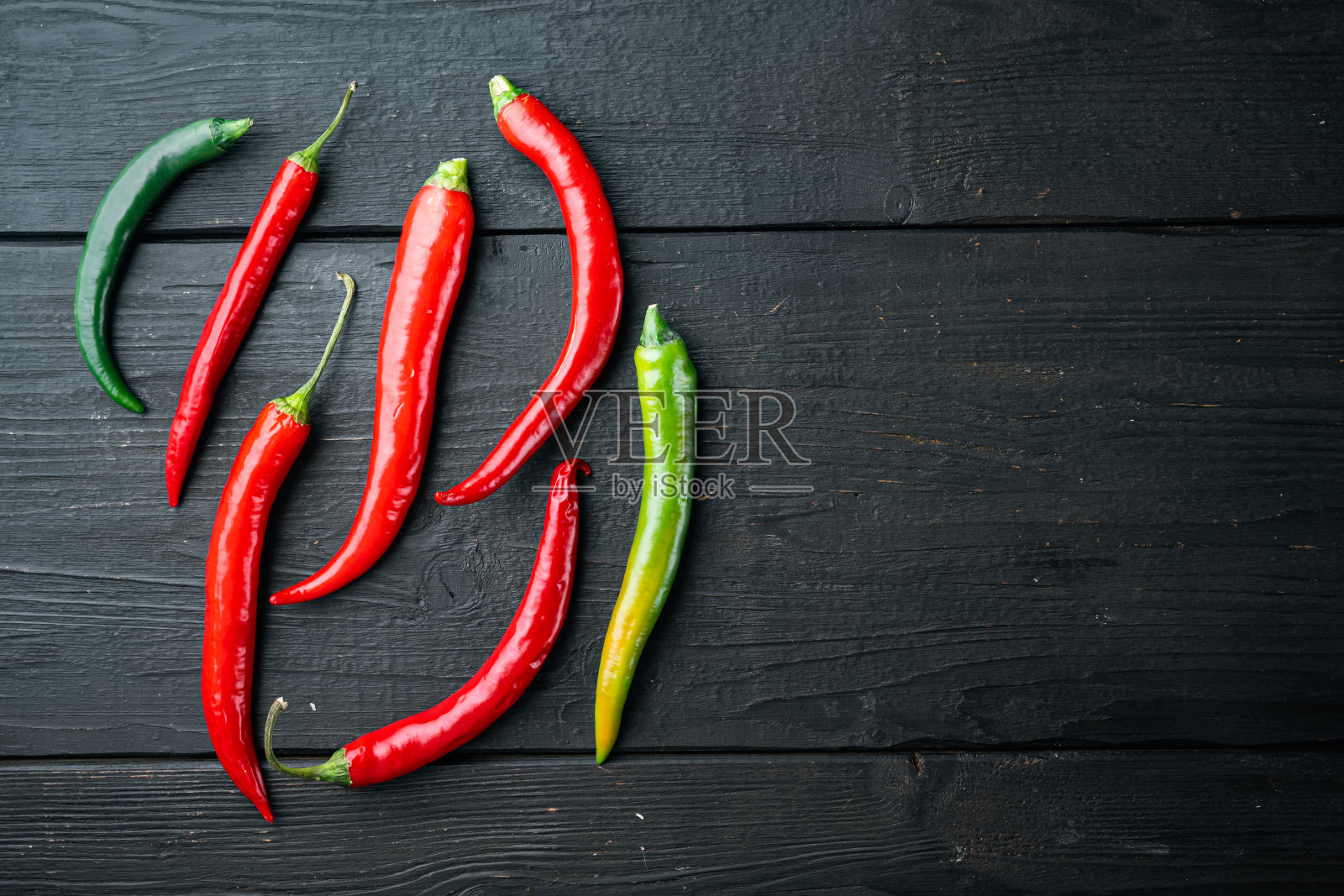 红色和绿色辣椒辣椒,在黑色木制桌子的背景,俯视图平铺,与copyspace和文本空间照片摄影图片