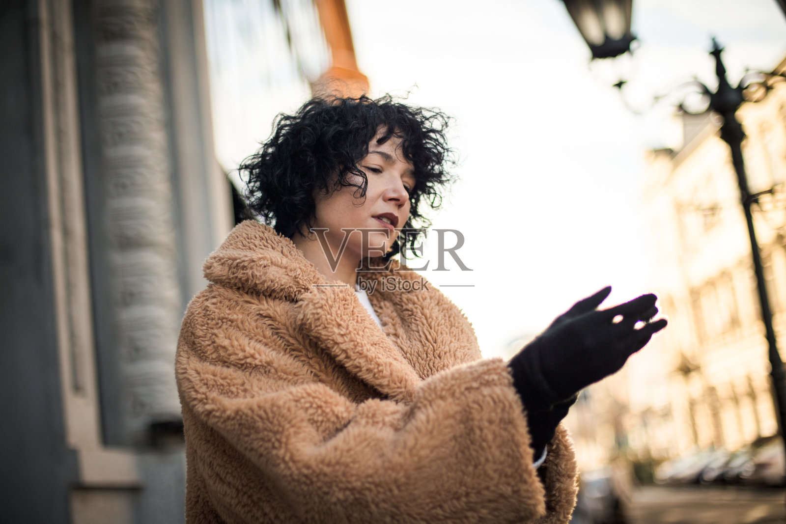 一个女人在街上戴着手套。照片摄影图片