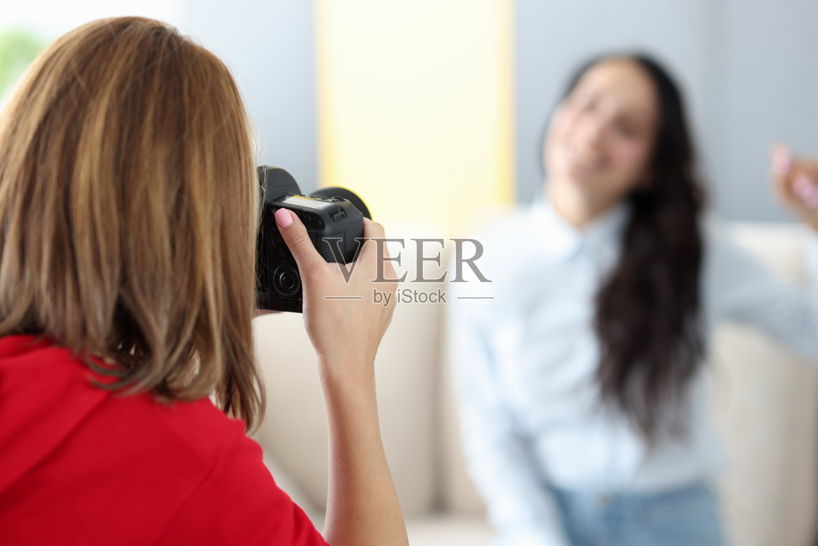 女摄影师在沙发上拍摄模特特写照片摄影图片